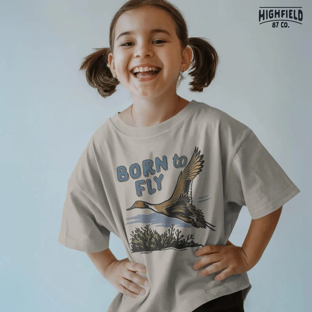 Hunting PNG featuring a duck flying low above swamp vegetation. Strong masculine design with “Born to Fly” message, good for outdoor apparel.