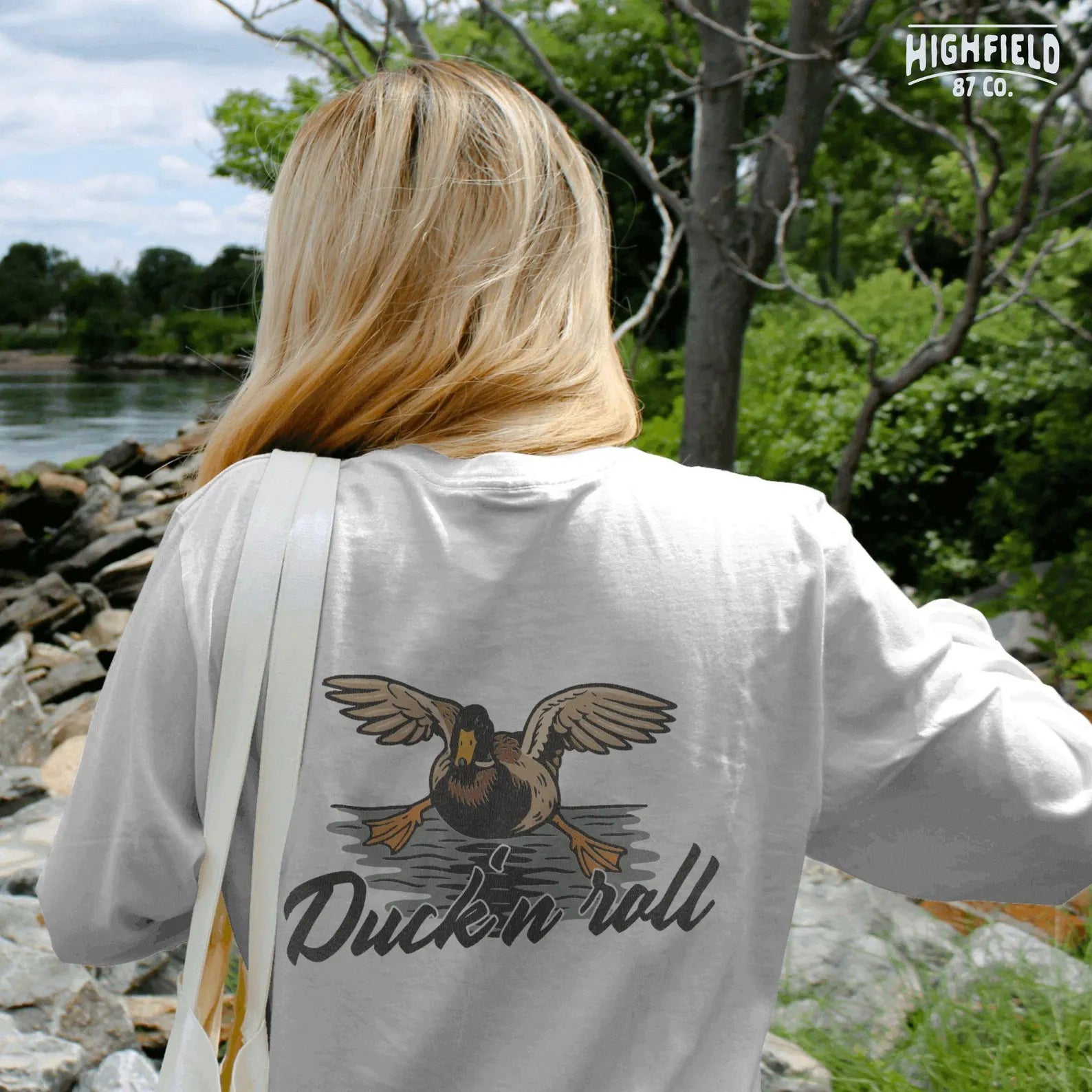 Duck in flight landing with open wings and big orange feet, phrase “Duck 'n Roll” written in bold script below. Ideal PNG for hunting gear or funny t-shirts.