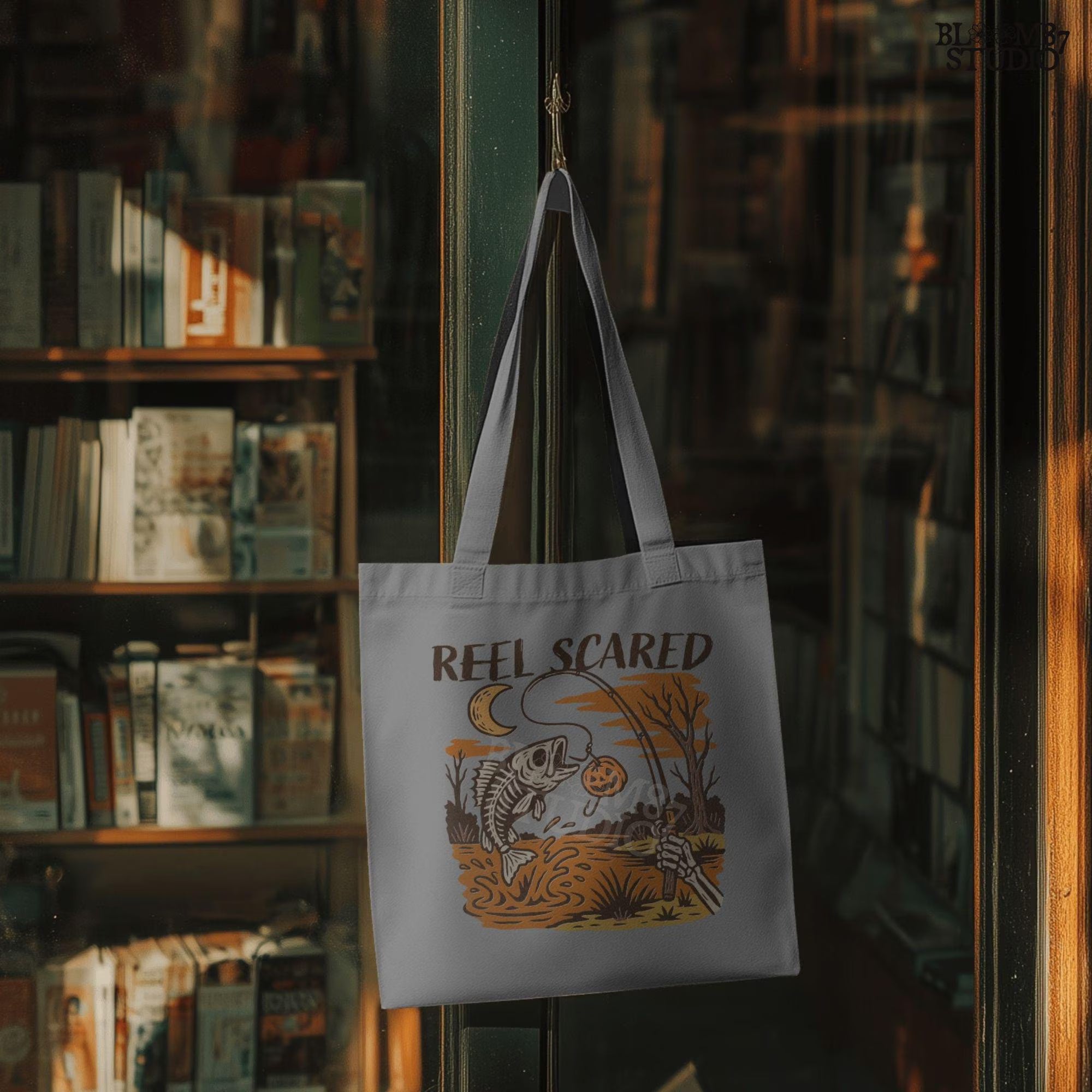 Tote bag with 'Reel Scared' design hanging in a bookstore