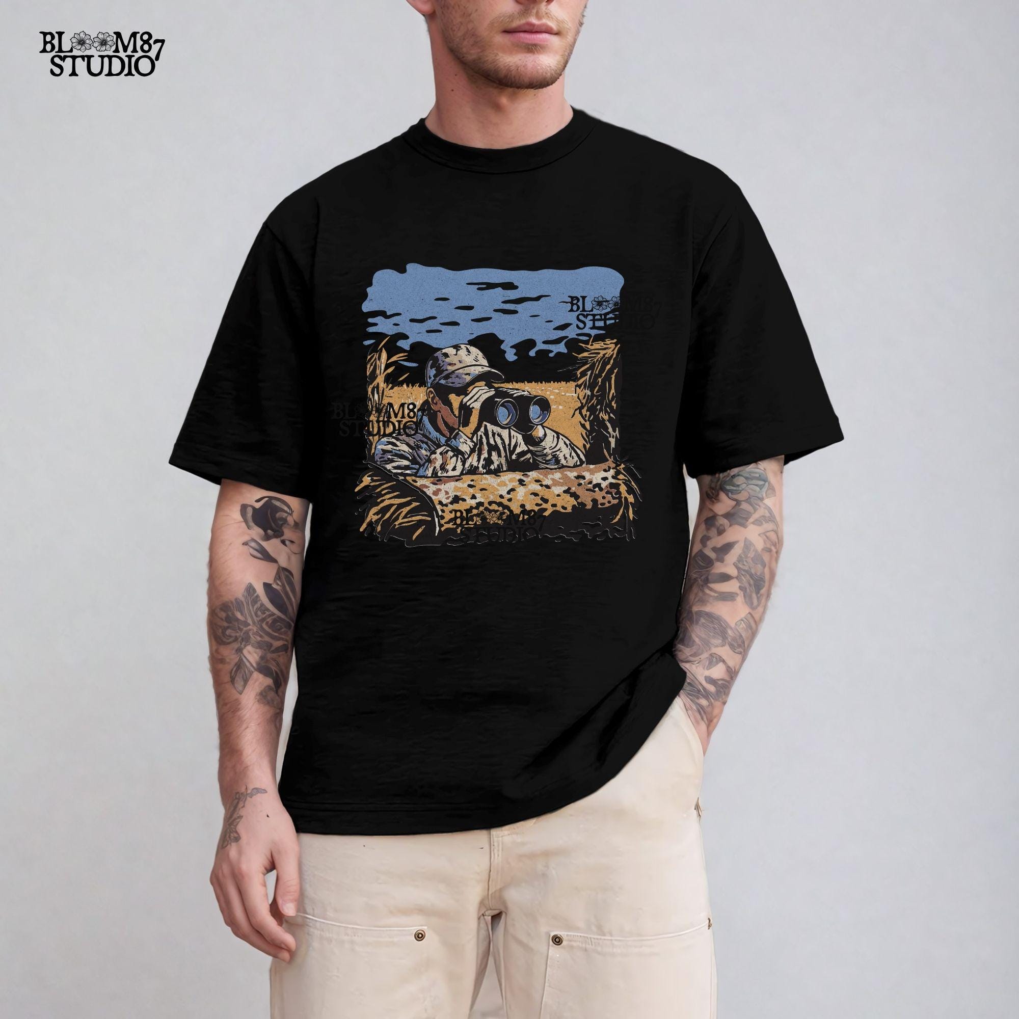 “Illustrated camouflage hunter peeking through binoculars from a duck blind, surrounded by tall grass, with a blue sky and golden field background. A detailed digital hunting-themed design, perfect for outdoorsmen, wildlife lovers, and hunting gear.”