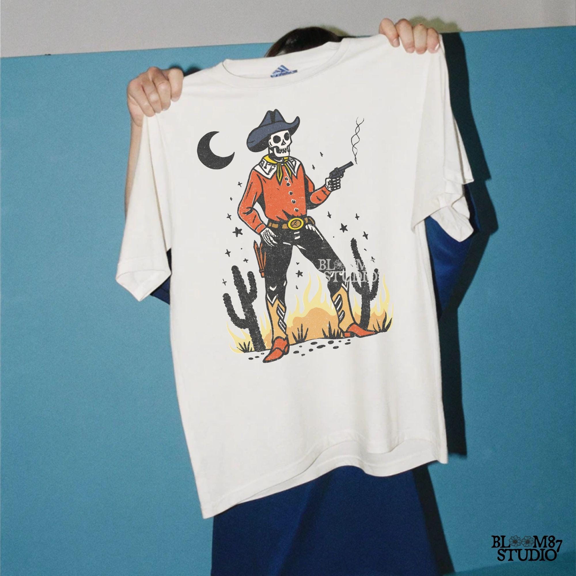 Vintage-style illustration of a skeleton cowboy in a red shirt and hat, holding a smoking revolver in a desert scene with cacti and fire.
