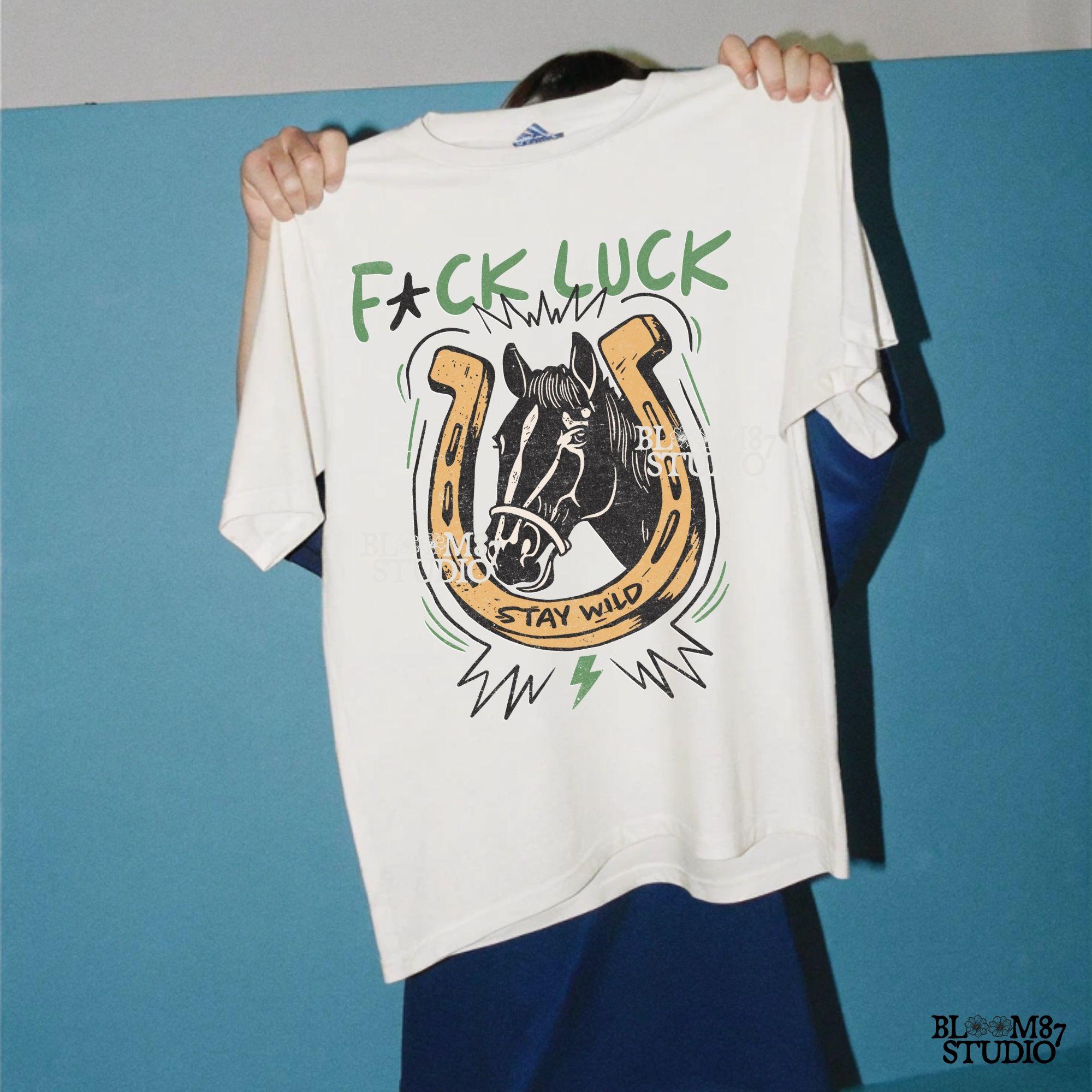 Vintage Western-style PNG featuring a horse inside a horseshoe with lightning bolts, the phrase “Stay Wild,” and an edgy rebellious message.