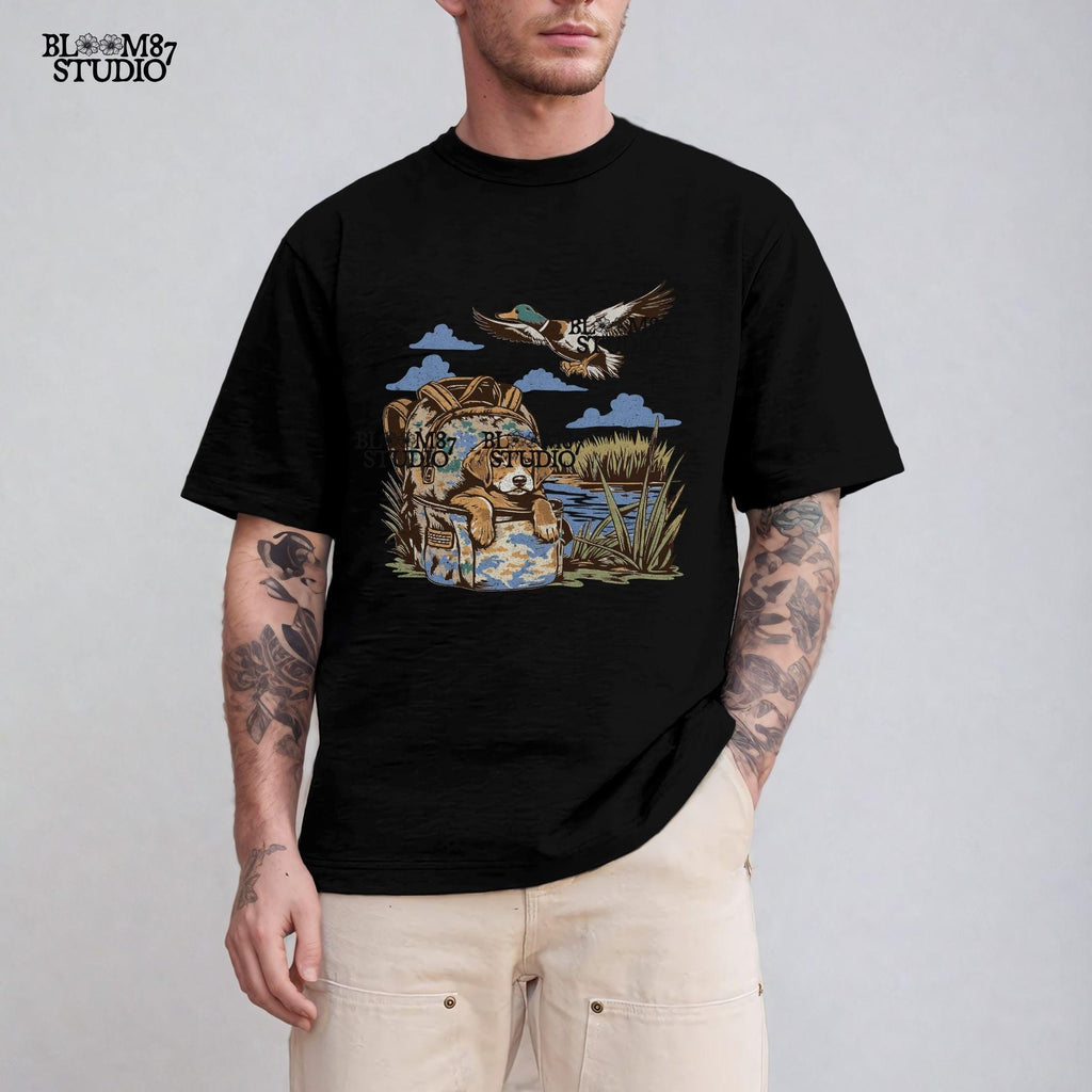 Illustration of a hunting dog resting in a camouflage bag near a pond, with a mallard duck flying overhead in a peaceful outdoor setting.