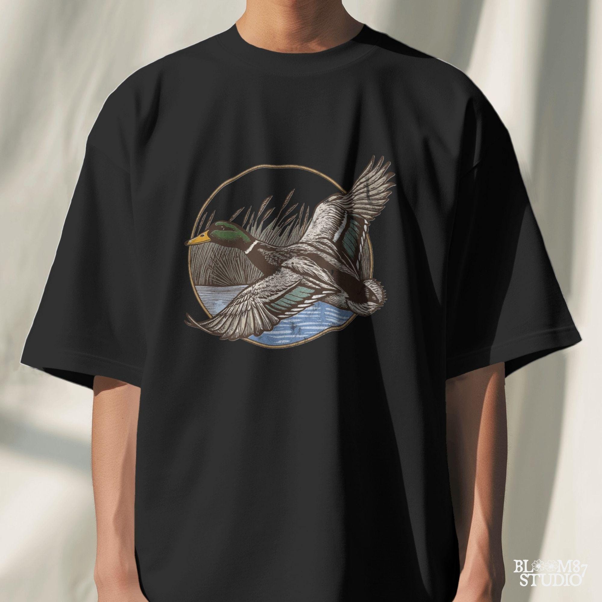 "Vintage flying mallard duck PNG clipart in marsh scene, rustic wildlife sublimation design for duck hunting shirts and outdoor gear"