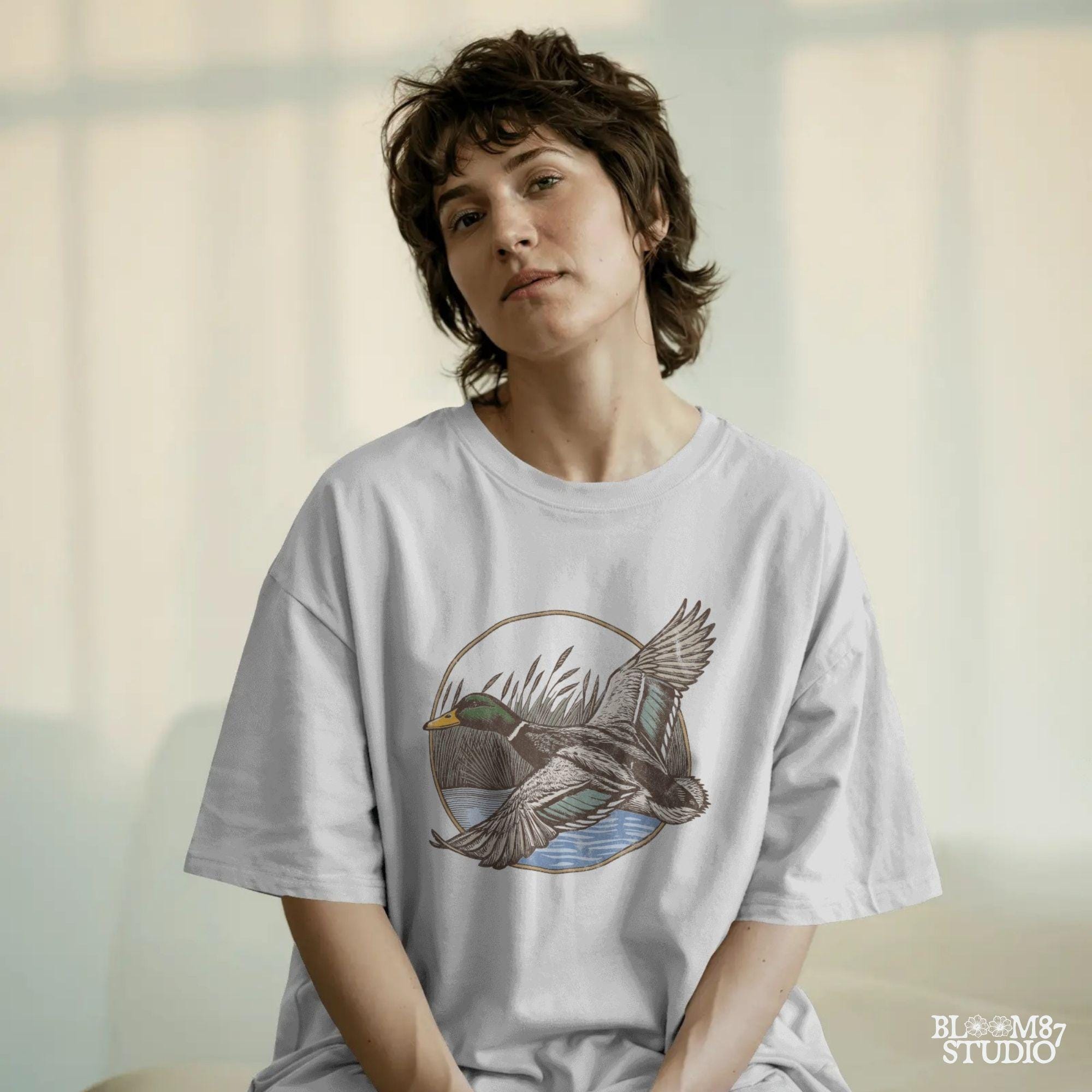 "Vintage flying mallard duck PNG clipart in marsh scene, rustic wildlife sublimation design for duck hunting shirts and outdoor gear"