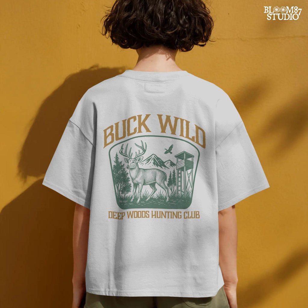 Illustration of a buck in the forest with mountains, a watchtower, and a bird, framed by the text “Buck Wild – Deep Woods Hunting Club”.