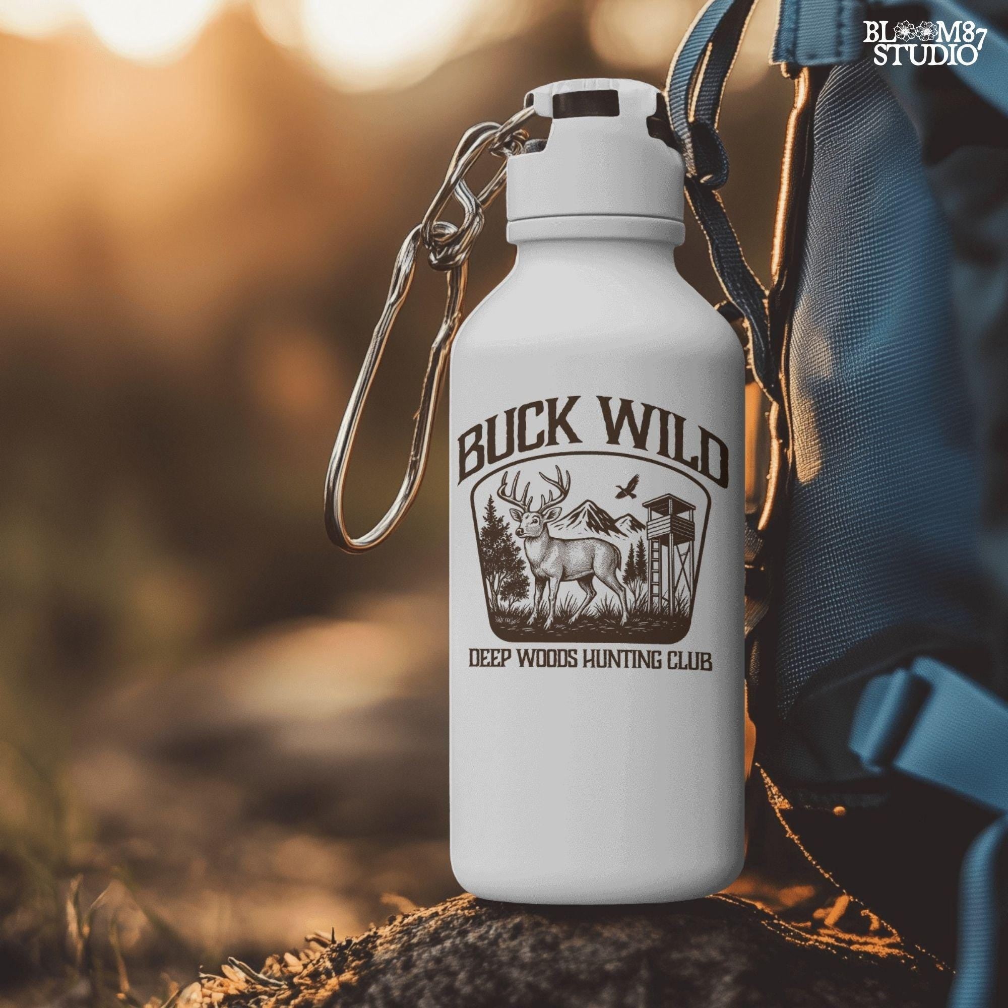 Illustration of a buck in the forest with mountains, a watchtower, and a bird, framed by the text “Buck Wild – Deep Woods Hunting Club”.
