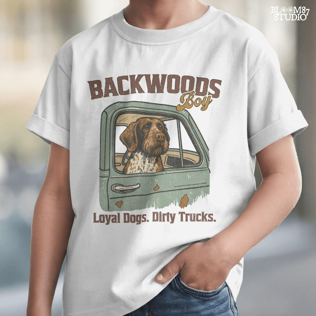 German Wirehaired Pointer hunting dog in rustic truck window with text “Backwoods Boy” and phrase “Loyal Dogs. Dirty Trucks.”