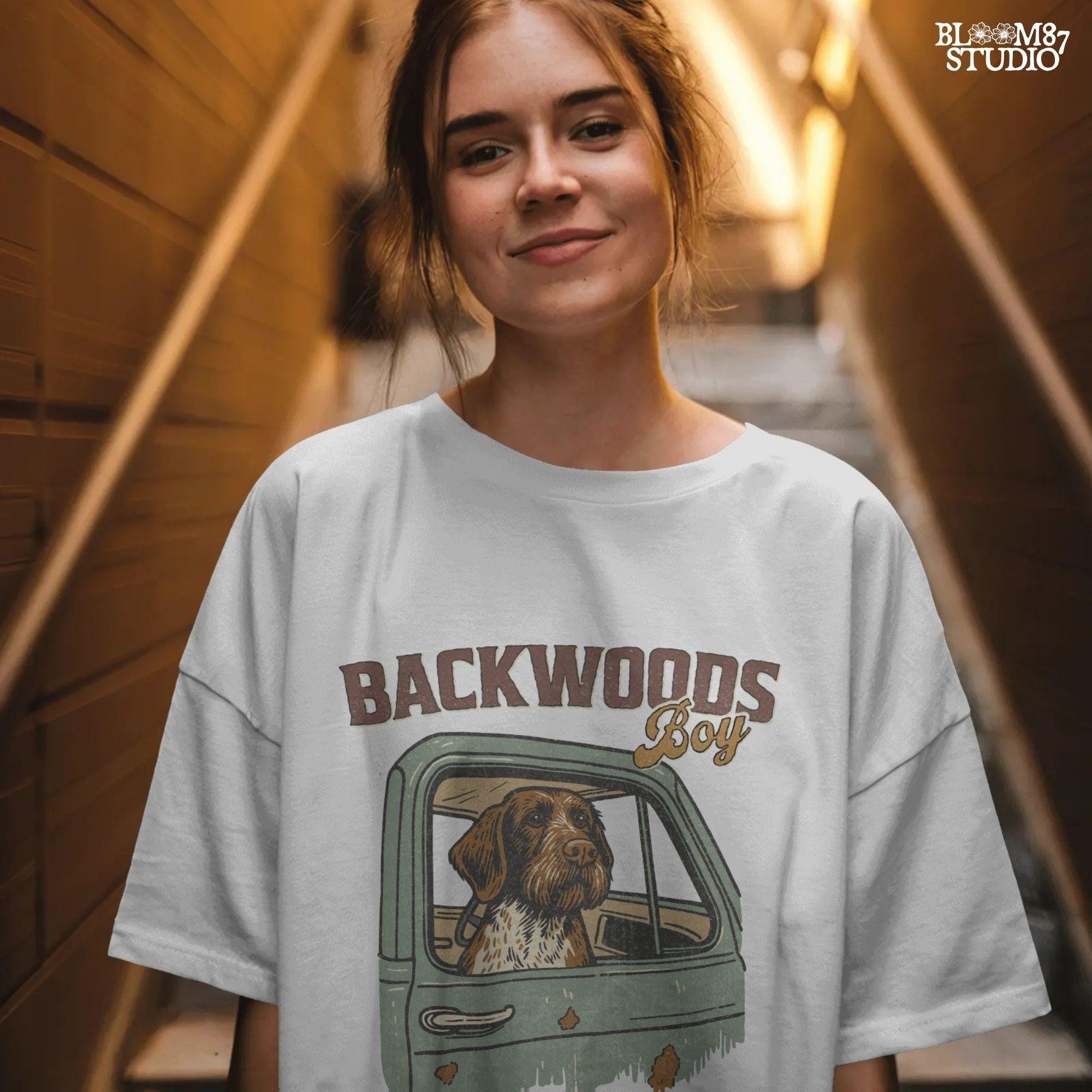 German Wirehaired Pointer hunting dog in rustic truck window with text “Backwoods Boy” and phrase “Loyal Dogs. Dirty Trucks.”