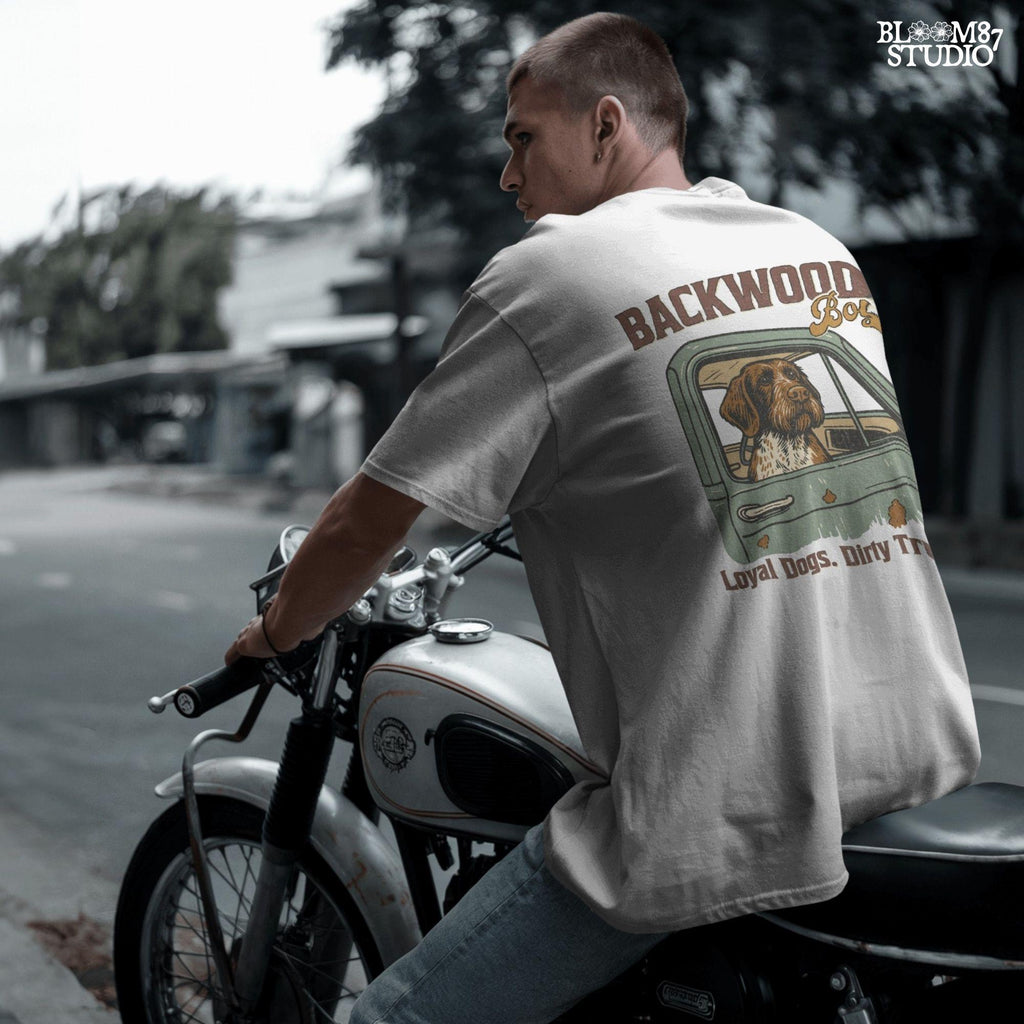 German Wirehaired Pointer hunting dog in rustic truck window with text “Backwoods Boy” and phrase “Loyal Dogs. Dirty Trucks.”