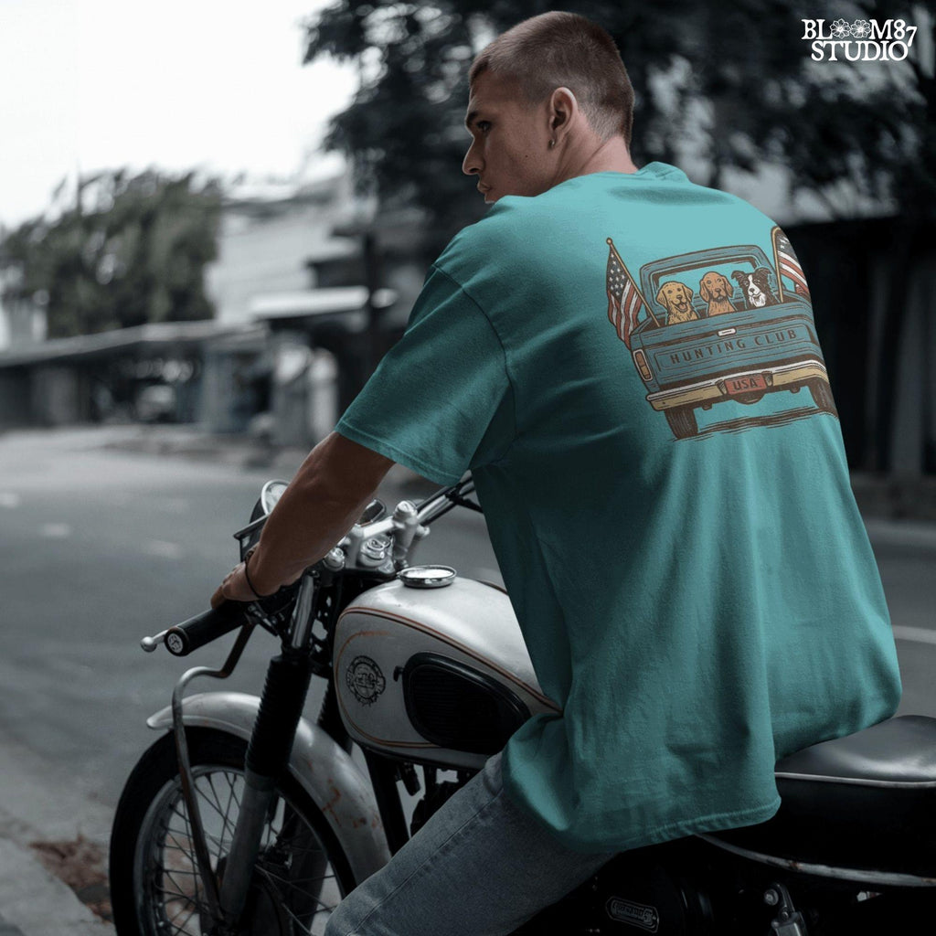 Three hunting dogs in the back of a blue vintage pickup truck with USA flags and “Hunting Club” text, patriotic hunting design for dog lovers.