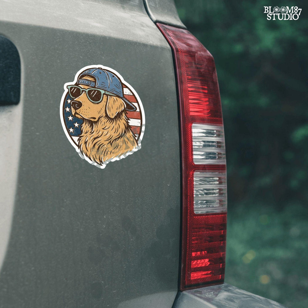 Cool golden retriever wearing sunglasses and a backwards cap in front of a circular American flag background.