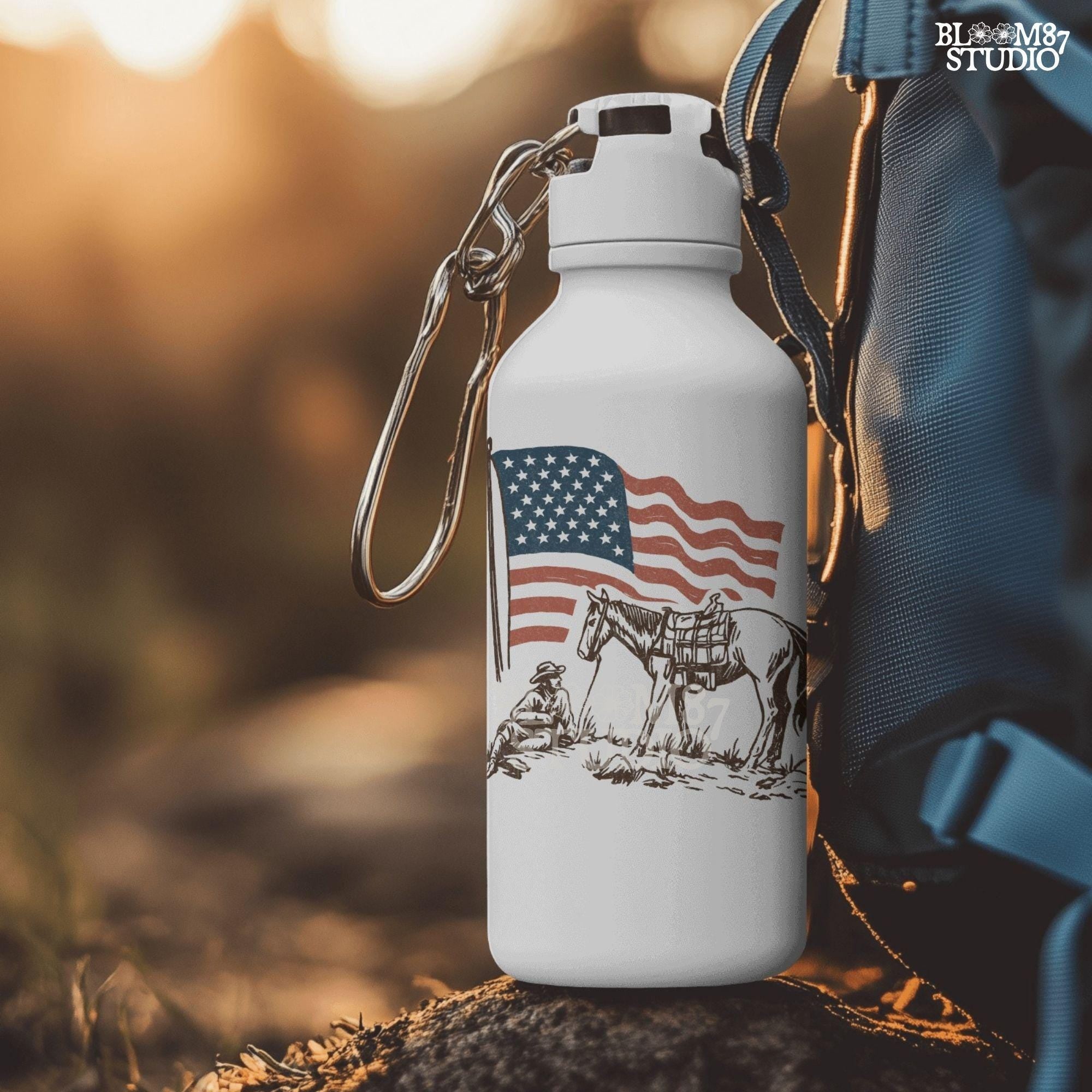 Vintage-style illustration of a cowboy sitting beside a saddled horse under a waving American flag.
