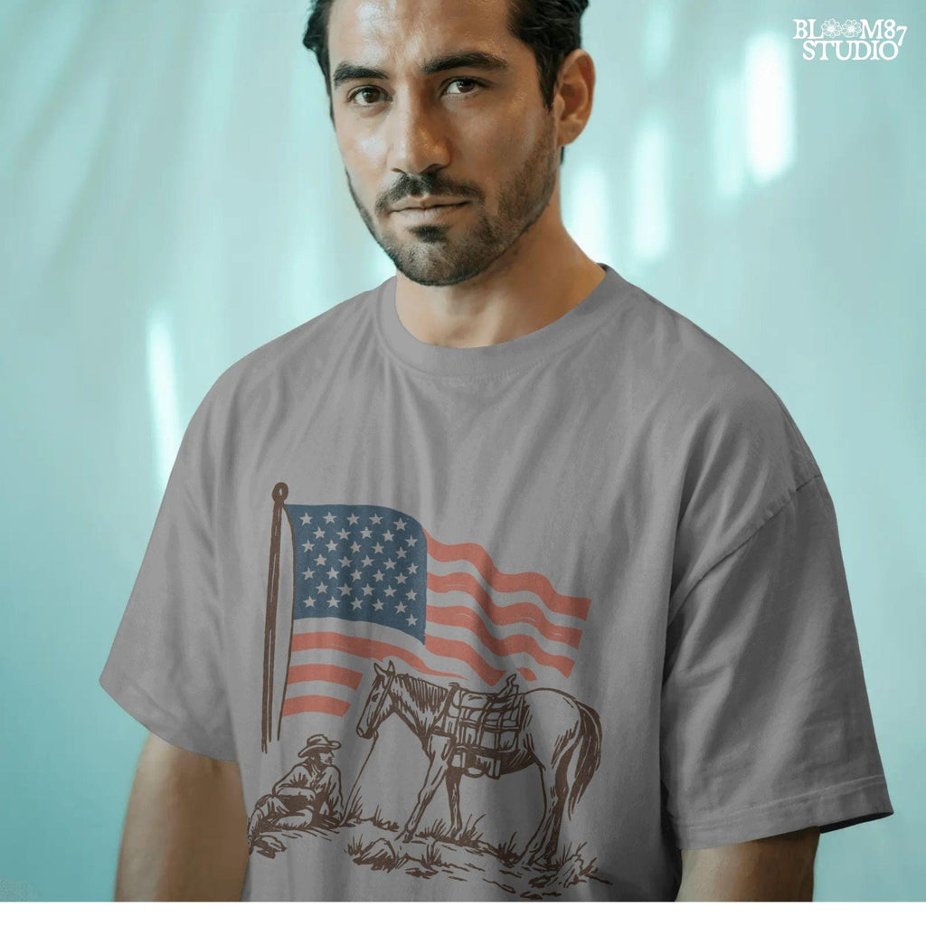 Vintage-style illustration of a cowboy sitting beside a saddled horse under a waving American flag.