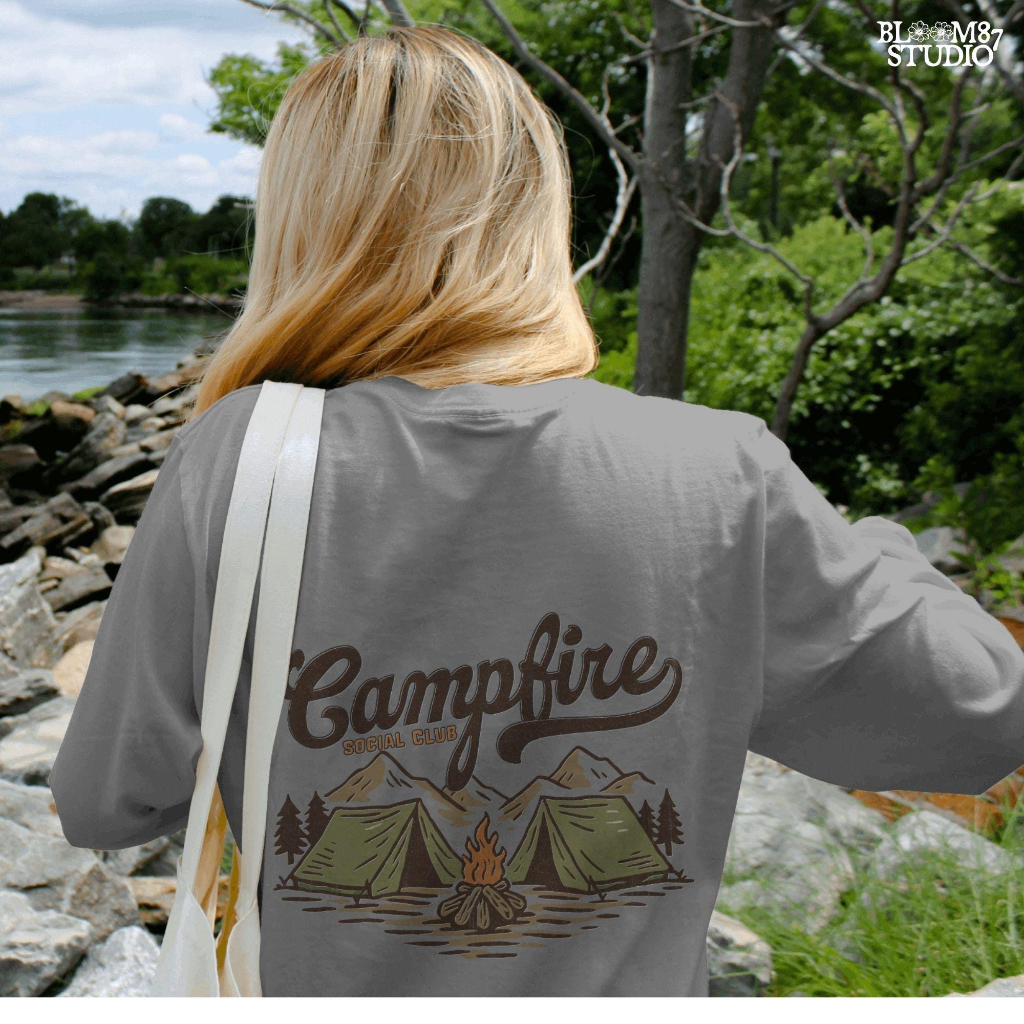 Vintage-style illustration of two camping tents, a lit campfire, pine trees, and mountains with the text “Campfire Social Club.”