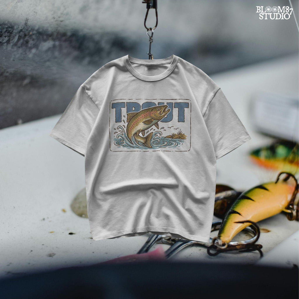 Vintage-style illustration of a rainbow trout jumping from the water in front of bold block letters spelling “TROUT”.
