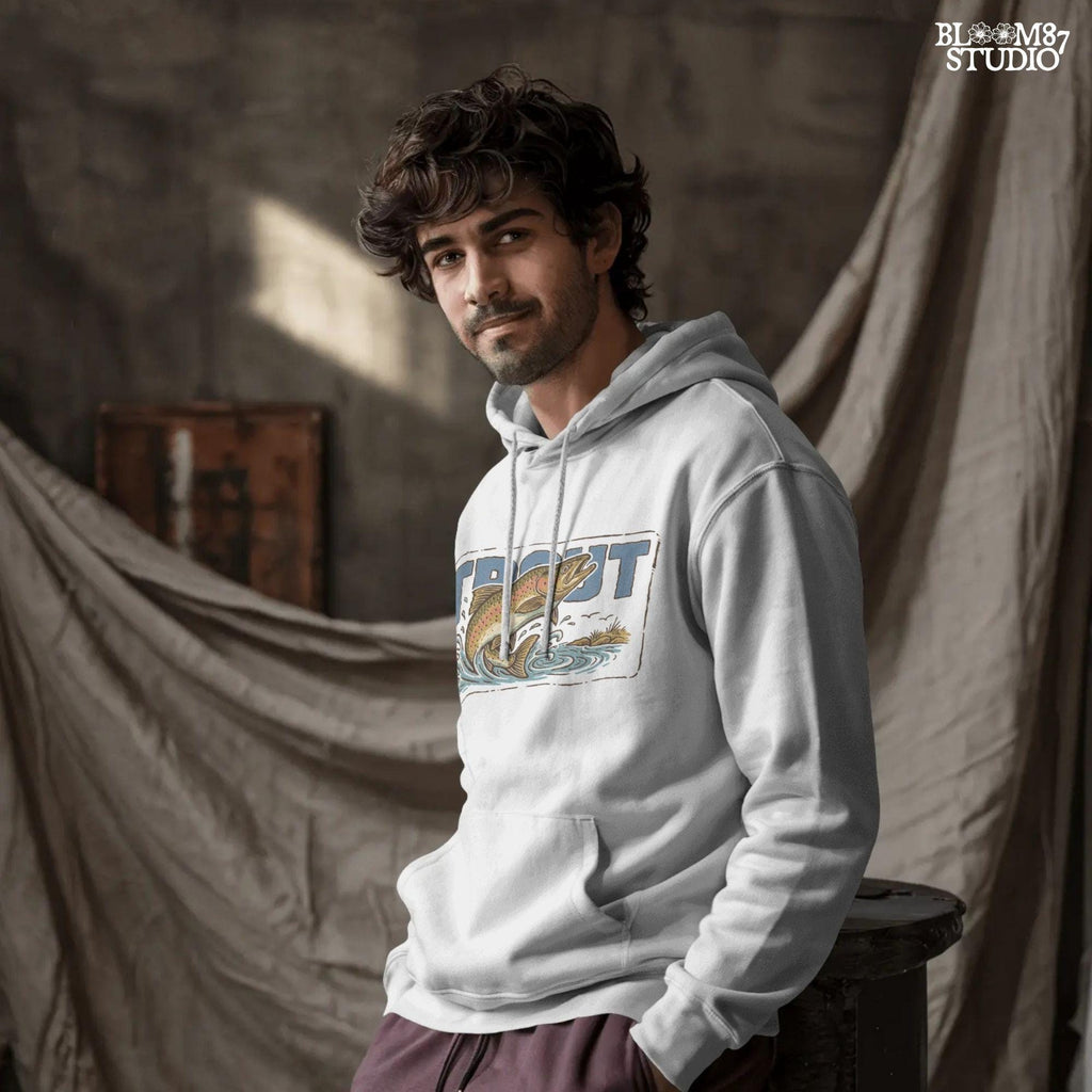 Vintage-style illustration of a rainbow trout jumping from the water in front of bold block letters spelling “TROUT”.