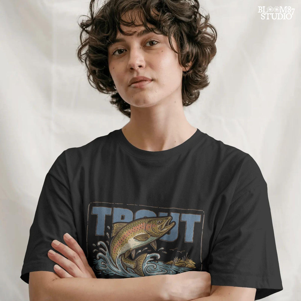 Vintage-style illustration of a rainbow trout jumping from the water in front of bold block letters spelling “TROUT”.