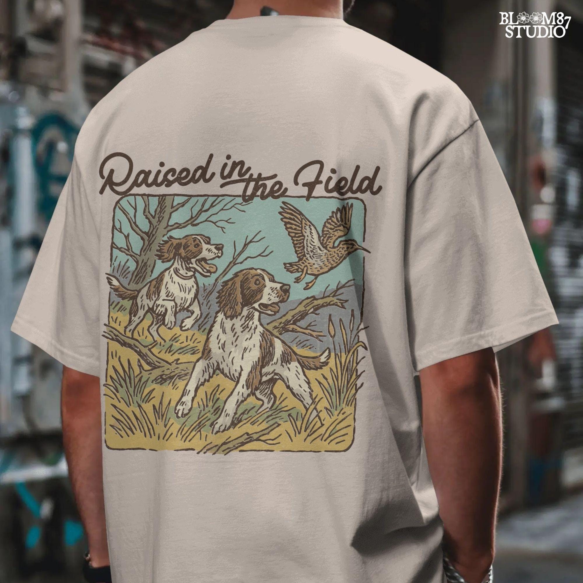 Rustic illustration of two Springer Spaniels flushing a game bird with the phrase “Raised in the Field” in vintage script.