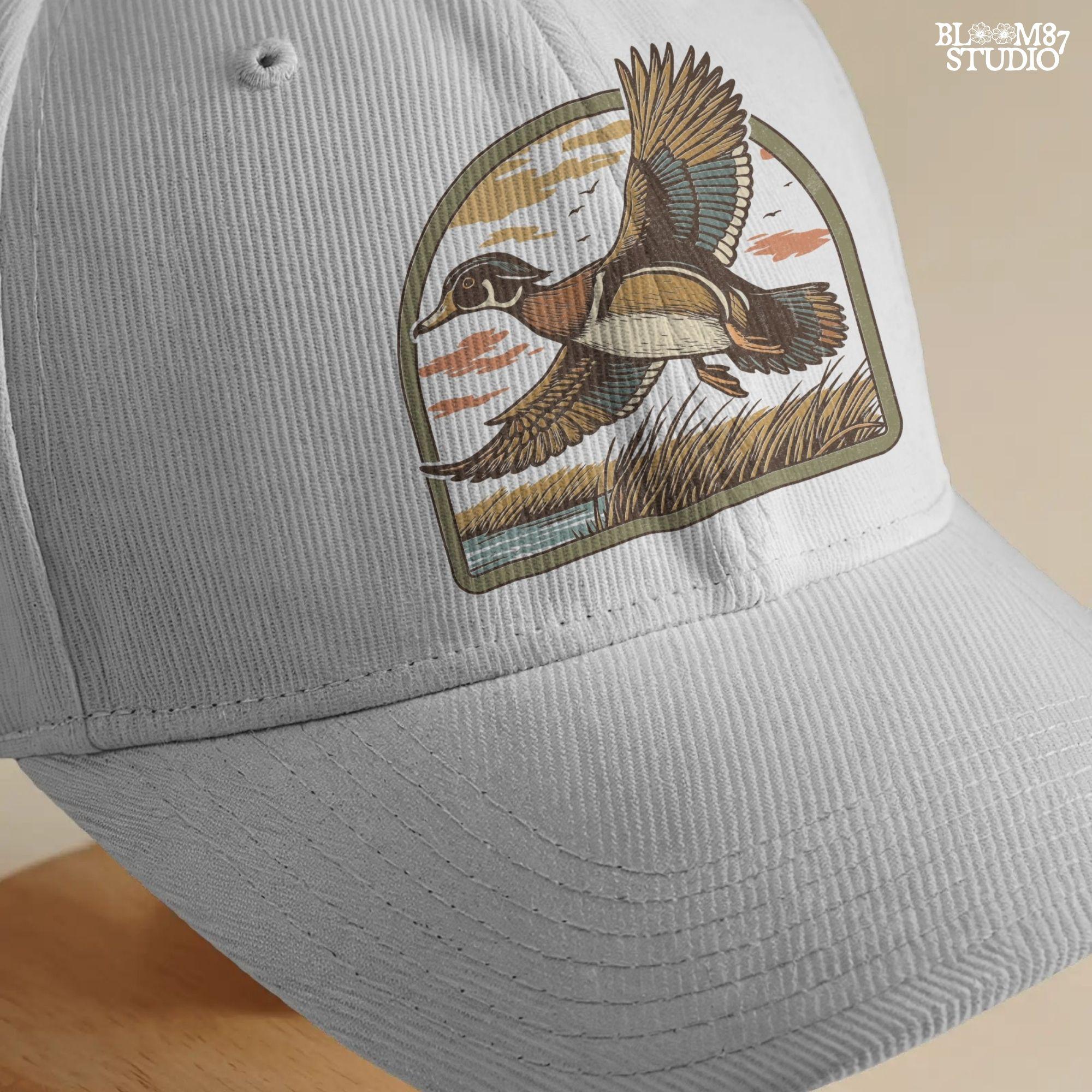 Illustration of a wood duck flying above a marsh at sunset with warm-toned clouds, cattails, and a reflective waterline.