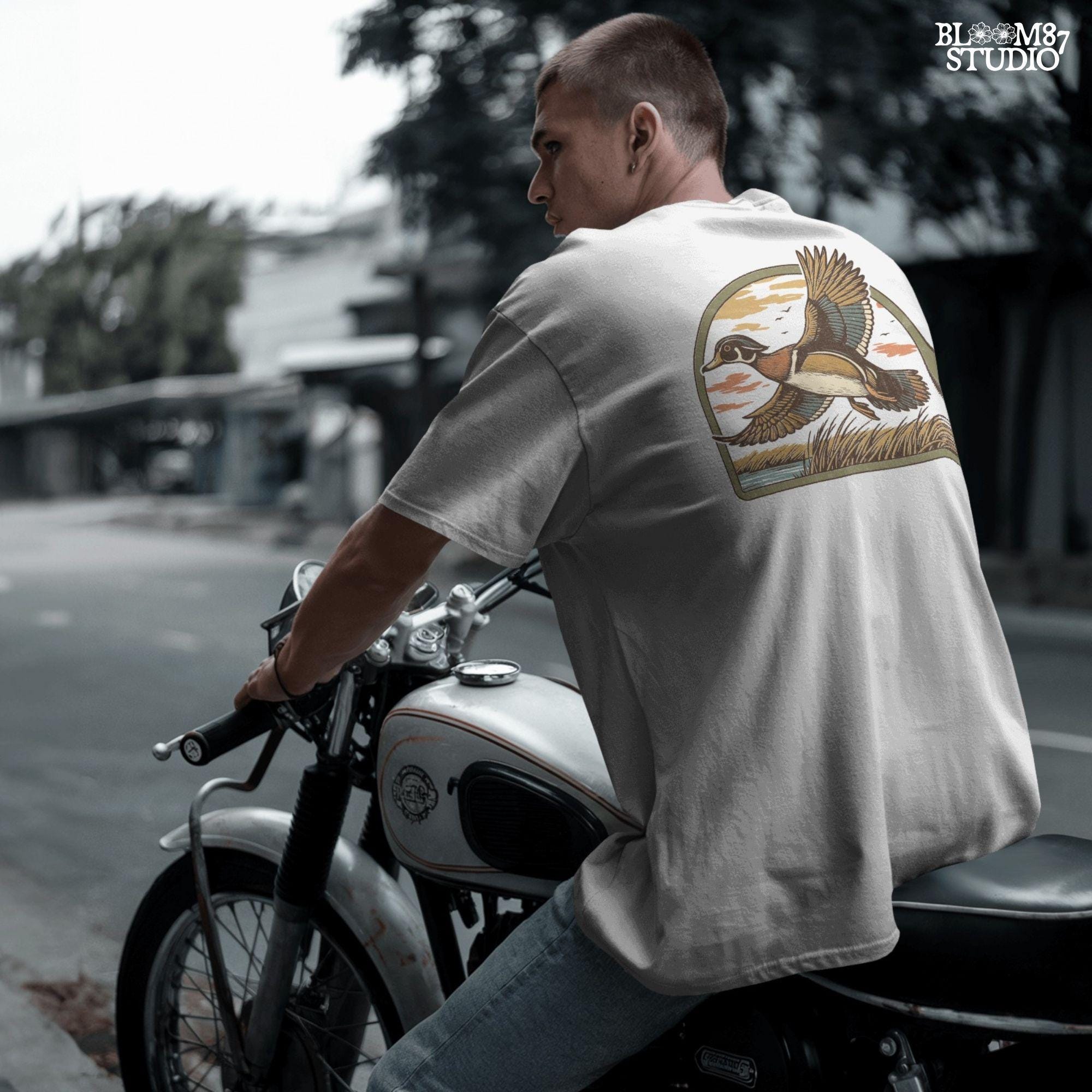 Illustration of a wood duck flying above a marsh at sunset with warm-toned clouds, cattails, and a reflective waterline.