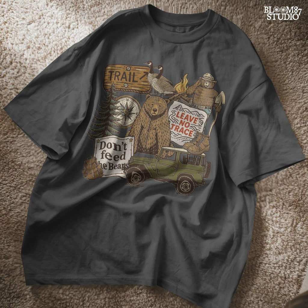 Illustration of a camping-themed collage featuring a grizzly bear, “Leave No Trace” sign, Smokey the Bear, trail sign, compass, boots, a green jeep, and forest scenery.