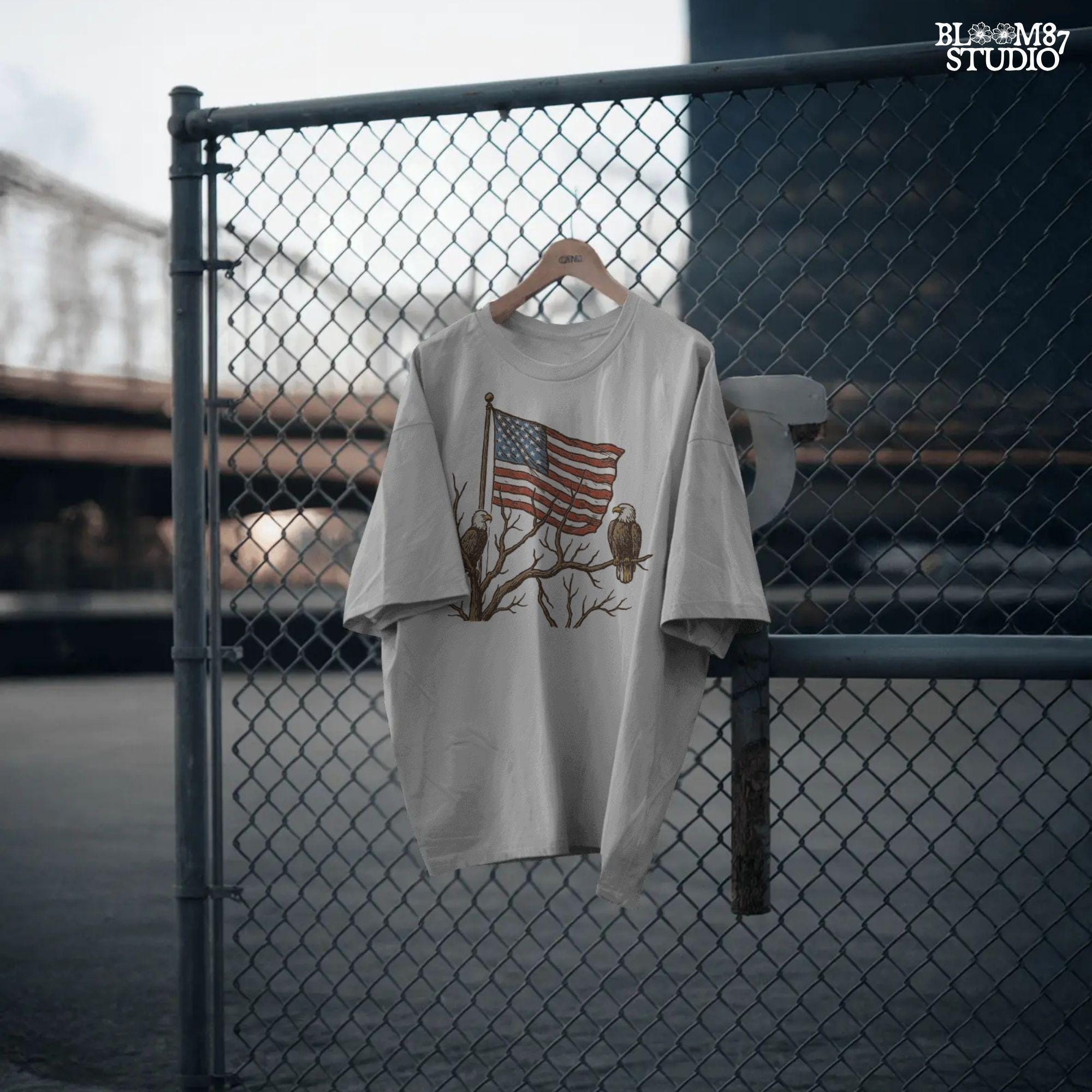 Two bald eagles perched on leafless tree branches in front of a waving American flag in a vintage-style illustration.