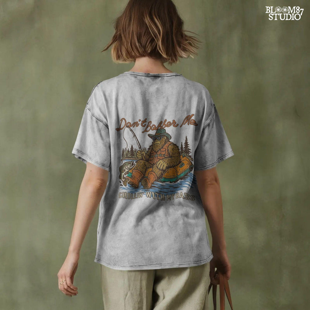 Funny Bigfoot sitting in a float tube holding a fishing rod and bass fish, wearing sunglasses and vest, with text “Don’t Bobber Me – Chillin’ with My Bass.”