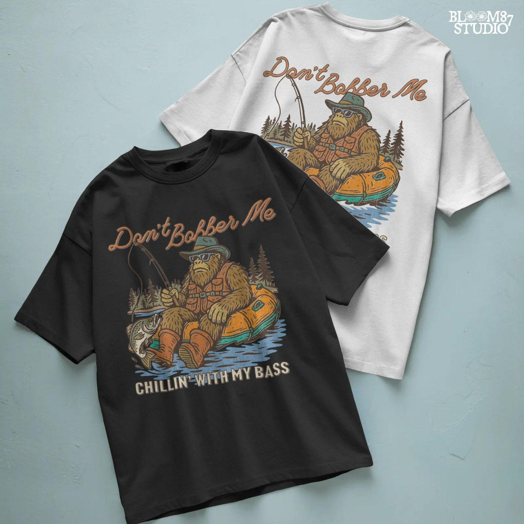 Funny Bigfoot sitting in a float tube holding a fishing rod and bass fish, wearing sunglasses and vest, with text “Don’t Bobber Me – Chillin’ with My Bass.”