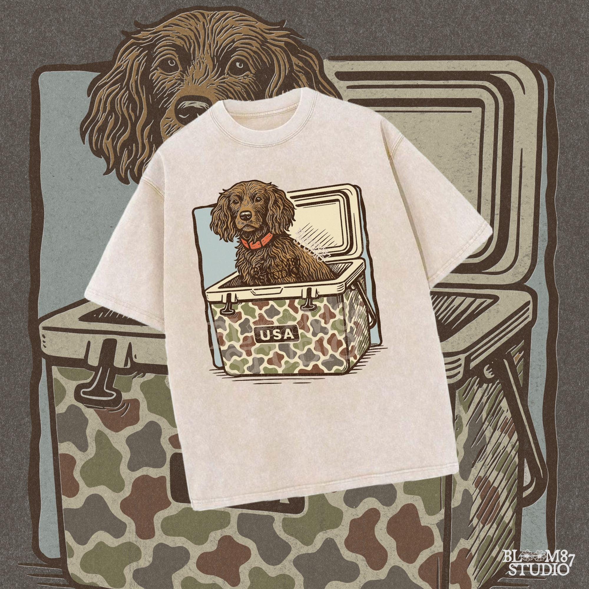 Hunting dog with curly fur sitting inside a camouflage cooler marked “USA” in a retro-style outdoors graphic.