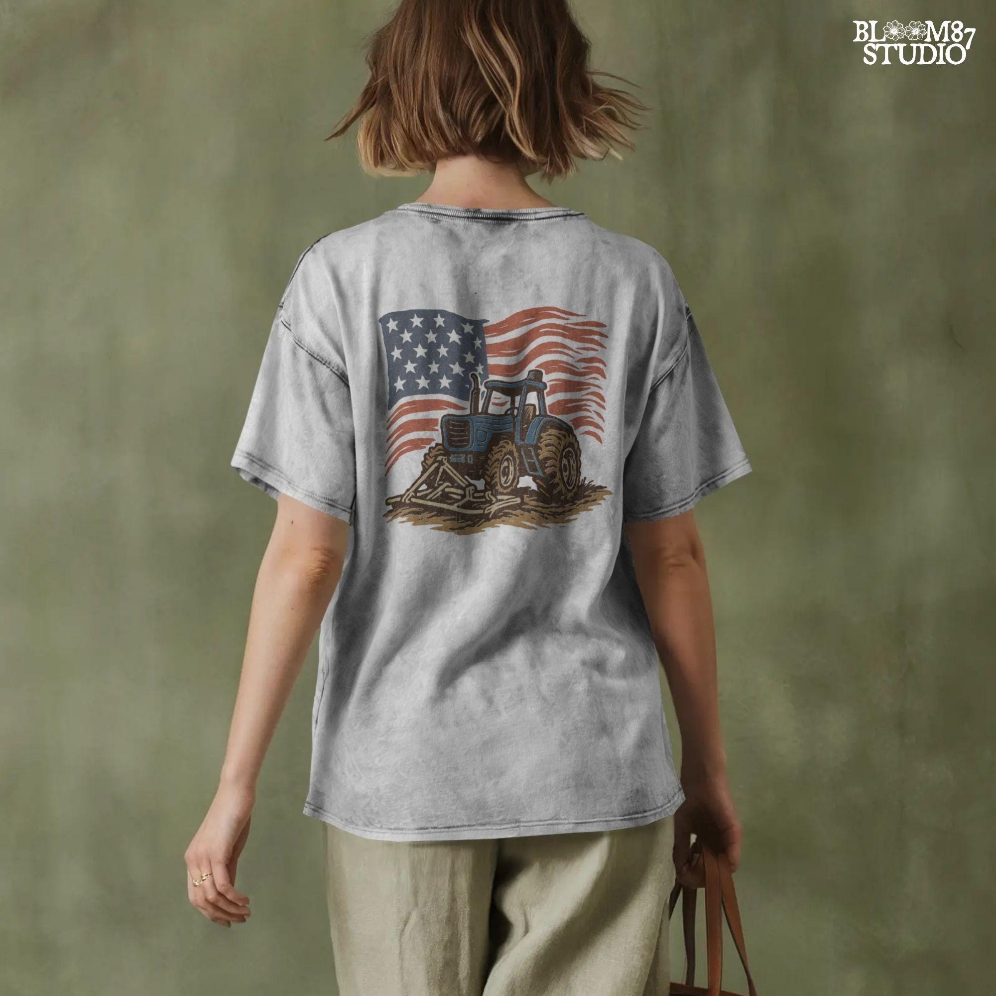 Red tractor with plow on soil, American flag waving in the background, vintage farm-themed graphic.