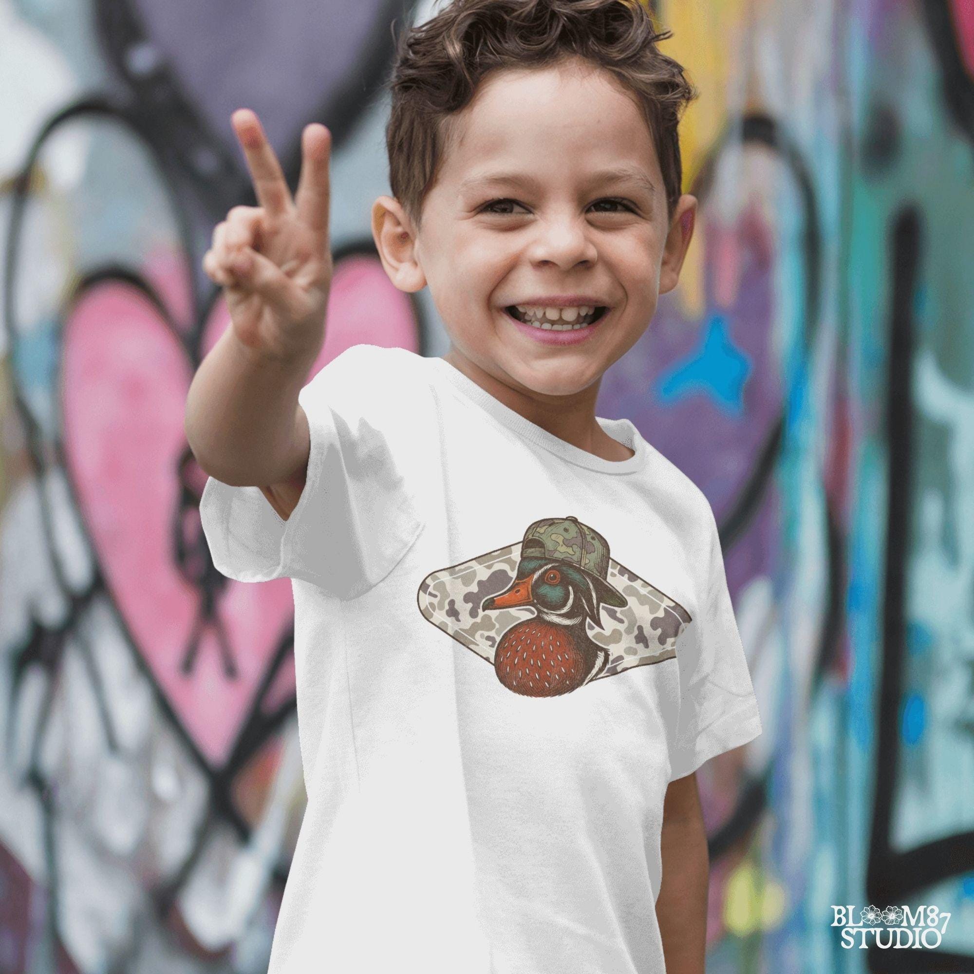 Funny wood duck wearing camo hat in front of marsh camo background – southern hunting sublimation design.