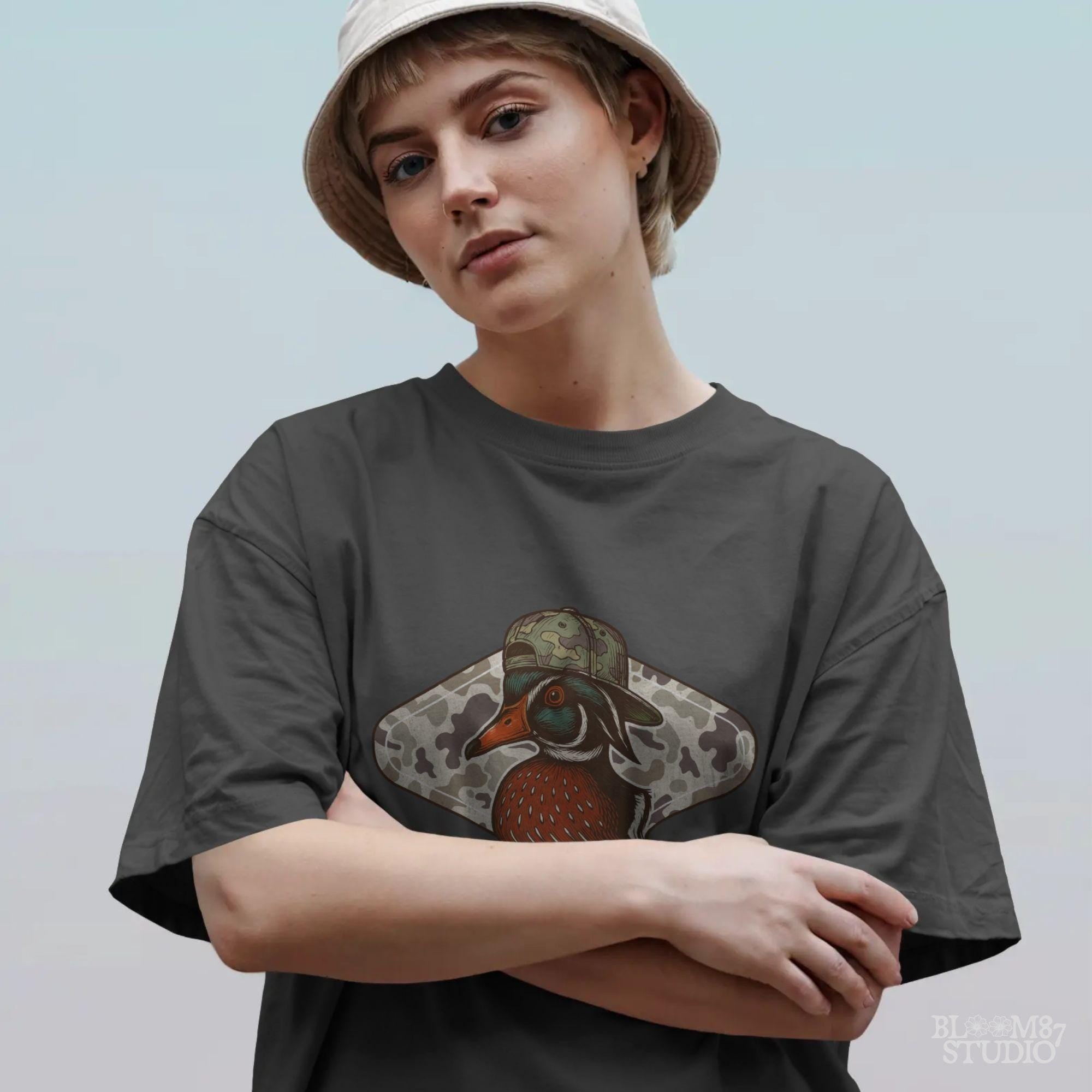 Funny wood duck wearing camo hat in front of marsh camo background – southern hunting sublimation design.