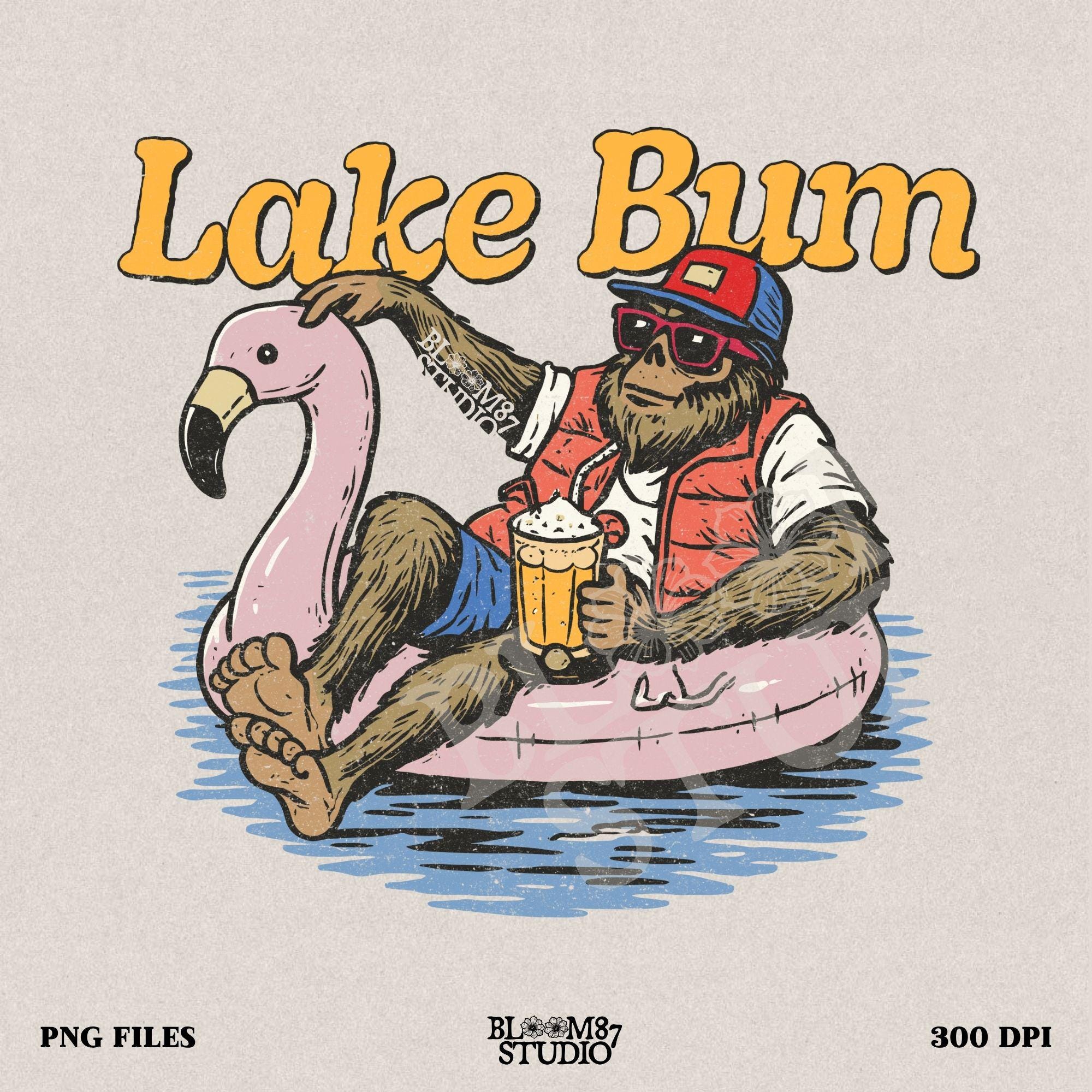 Bigfoot lounging on a pink flamingo float with a beer, wearing summer gear and sunglasses, with “Lake Bum” text above.