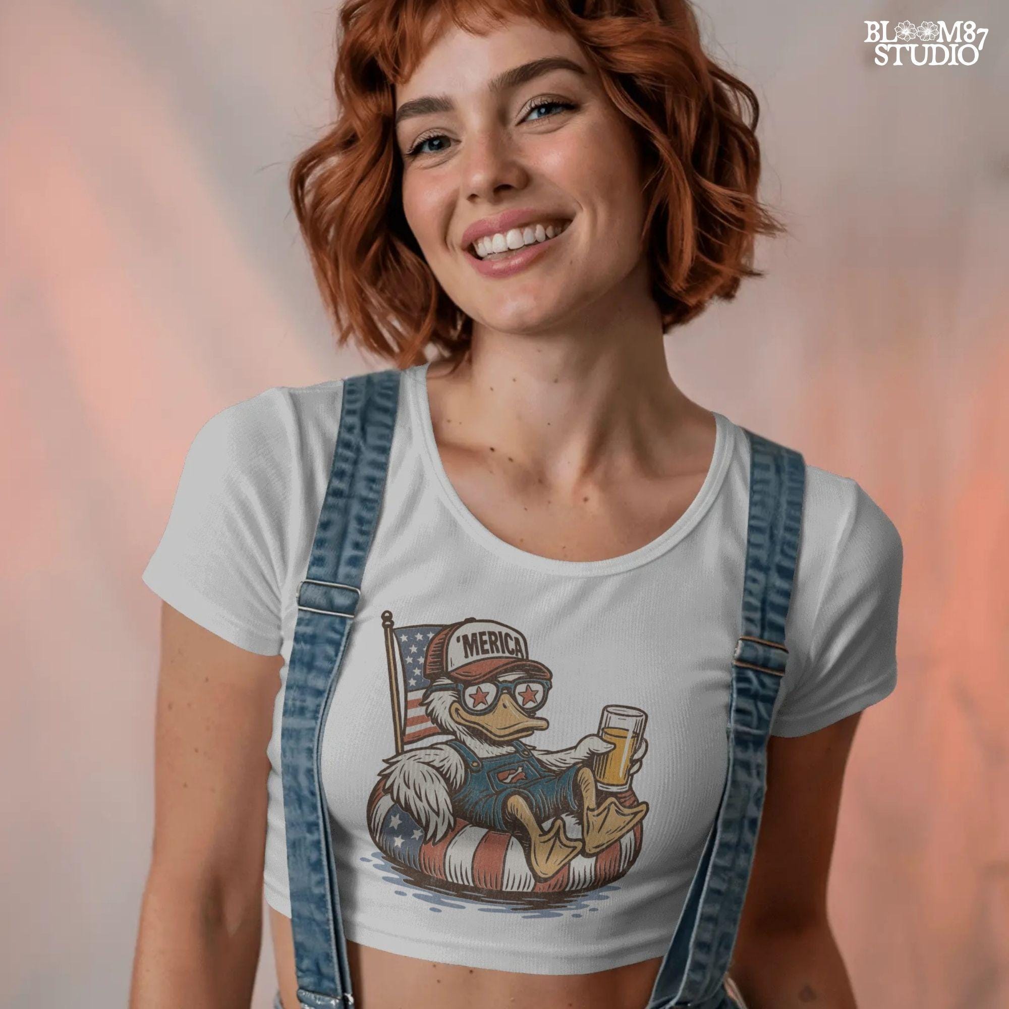 Cartoon duck lounging on a red, white, and blue floaty, wearing sunglasses and a ‘Merica cap, holding a beer with American flag background.