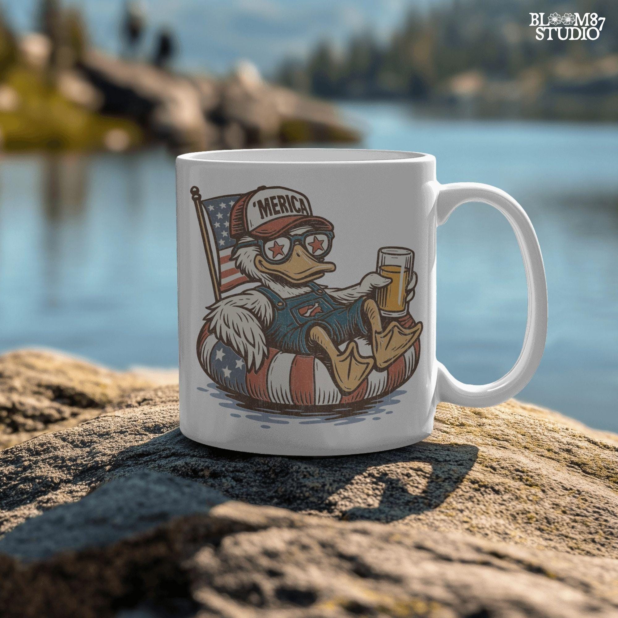 Cartoon duck lounging on a red, white, and blue floaty, wearing sunglasses and a ‘Merica cap, holding a beer with American flag background.
