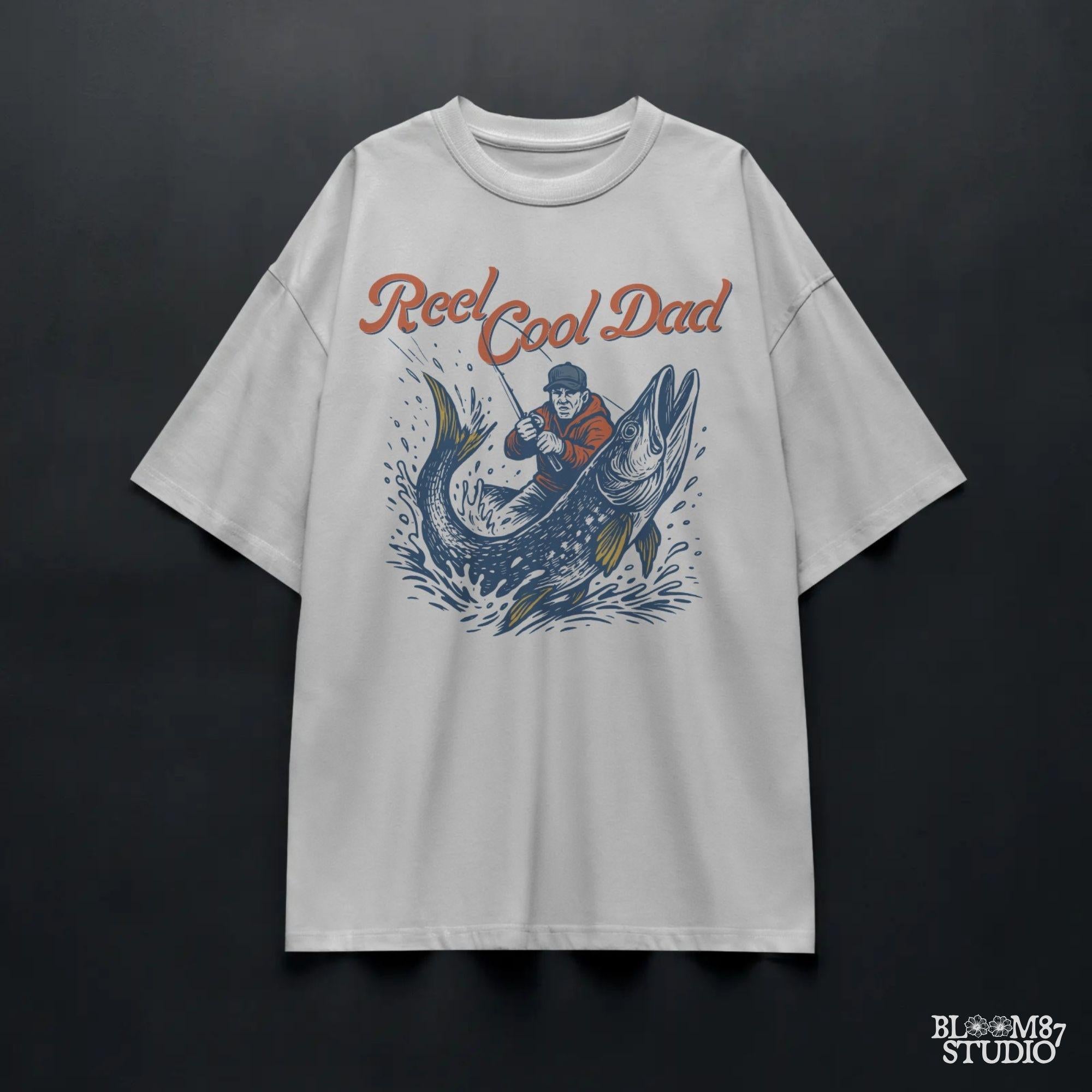 Illustration of a father reeling in a giant fish with bold text “Reel Cool Dad,” perfect for Father’s Day or fishing-themed gifts.