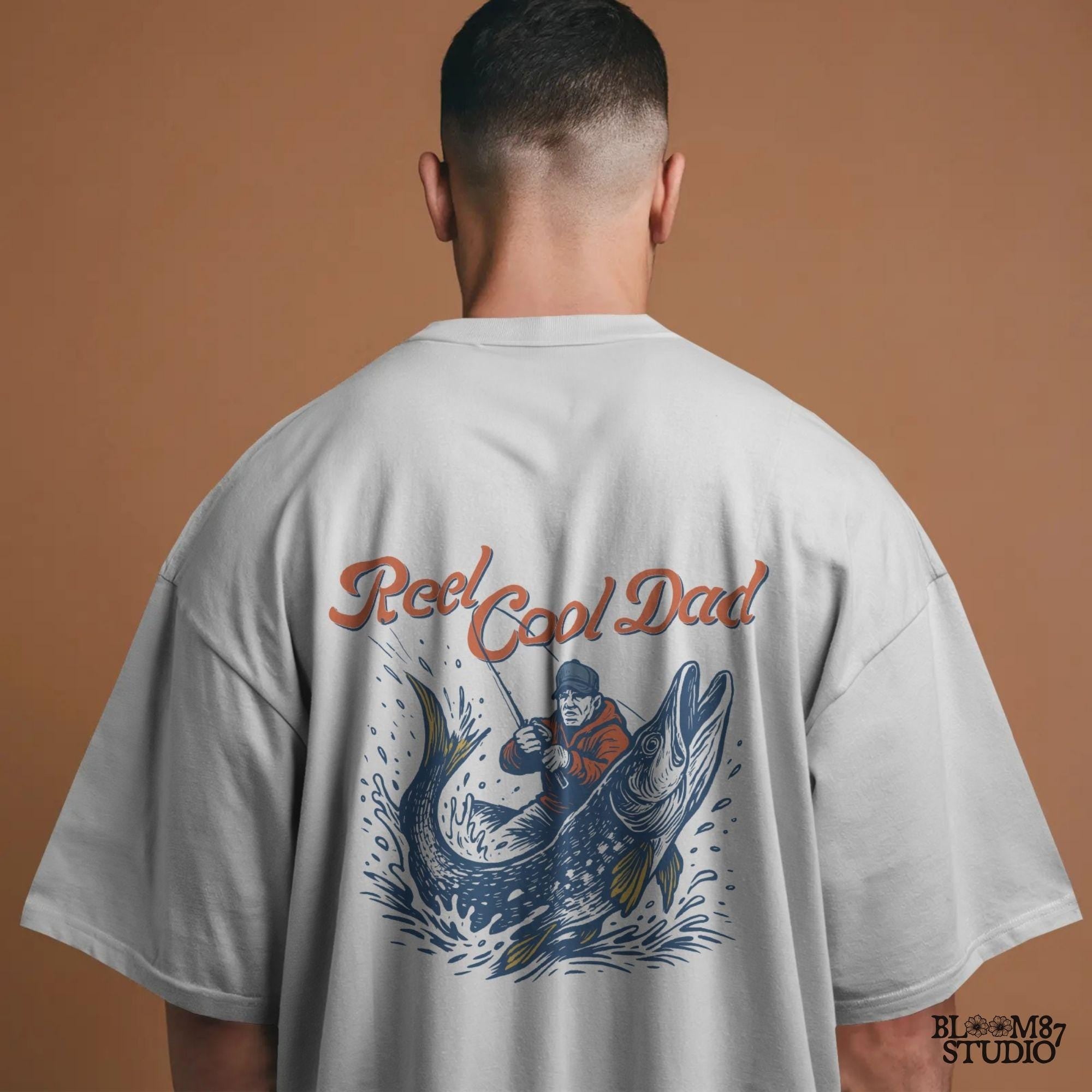 Illustration of a father reeling in a giant fish with bold text “Reel Cool Dad,” perfect for Father’s Day or fishing-themed gifts.