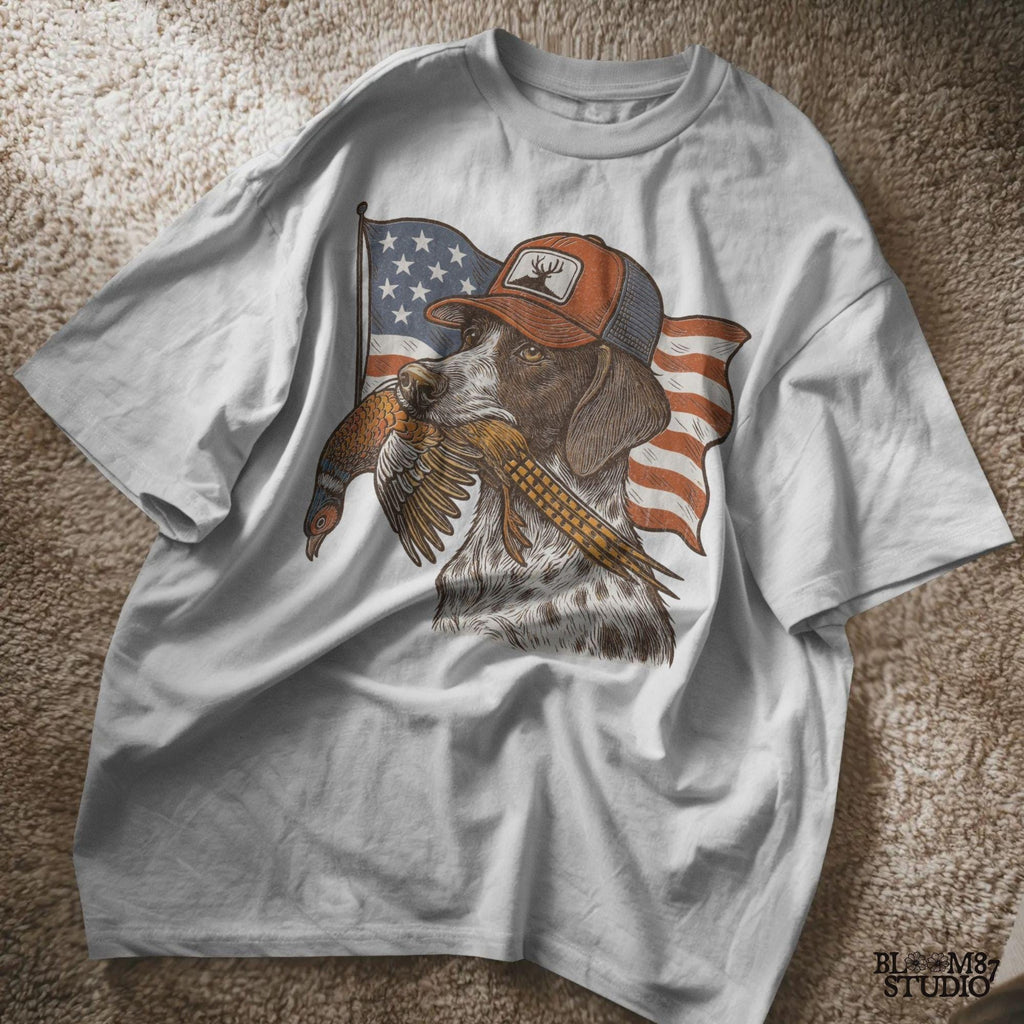Hunting dog wearing a cap and holding a pheasant in its mouth, with a waving American flag in the background.