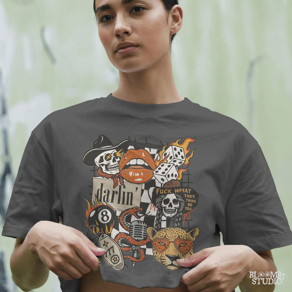 Western punk collage design featuring skulls, lips, leopard with heart glasses, snake and microphone, dice, barbed wire, and 777 tag.