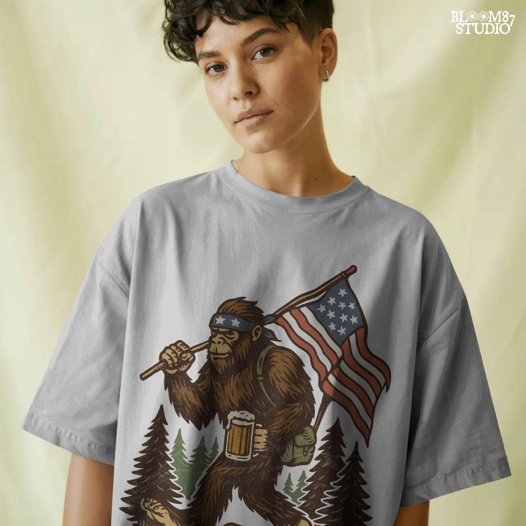 Patriotic bigfoot carrying American flag and beer mug in forest, funny summer USA PNG design.
