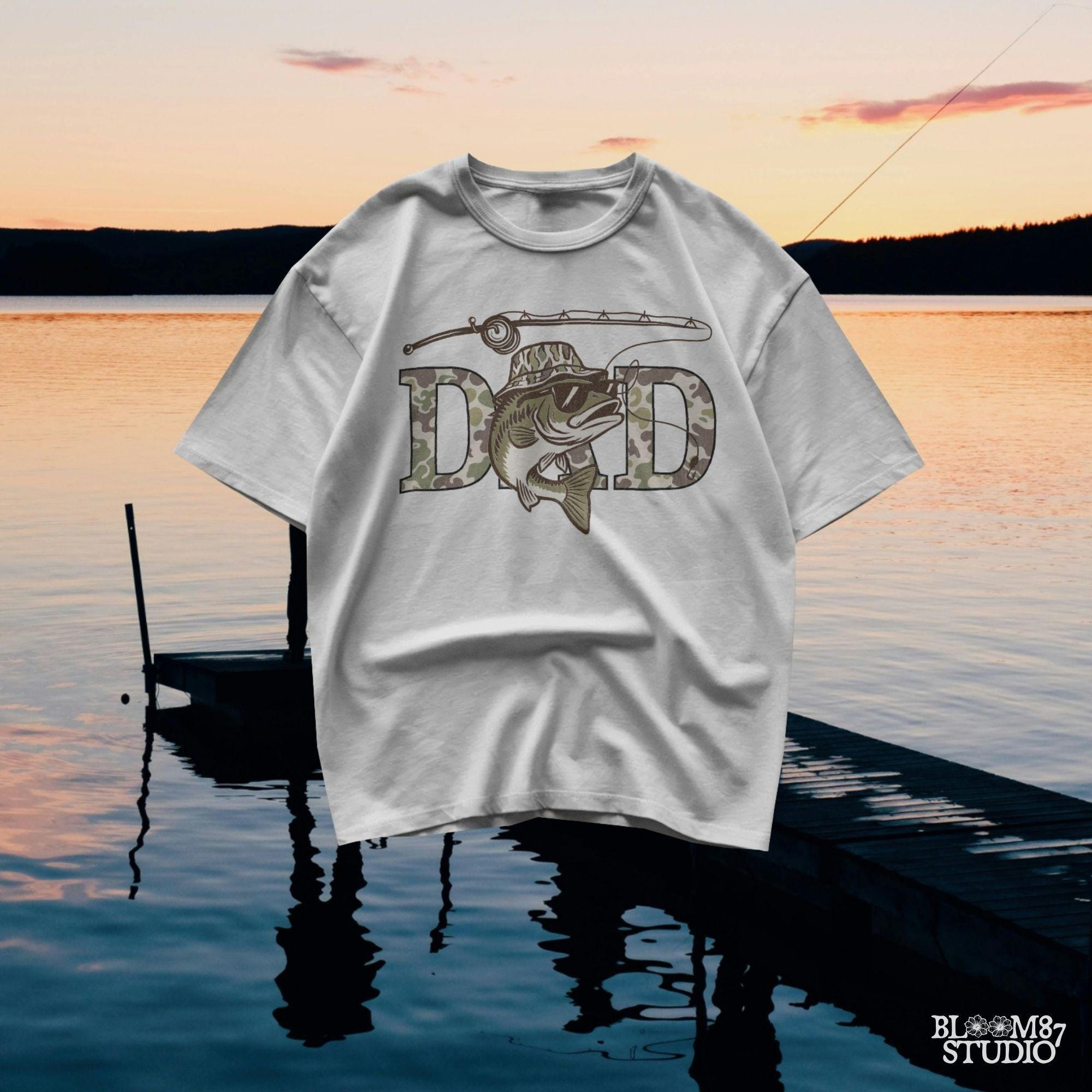 A funny camo bass fish wearing sunglasses and a camo bucket hat, with large camouflage DAD lettering and a fishing pole above.