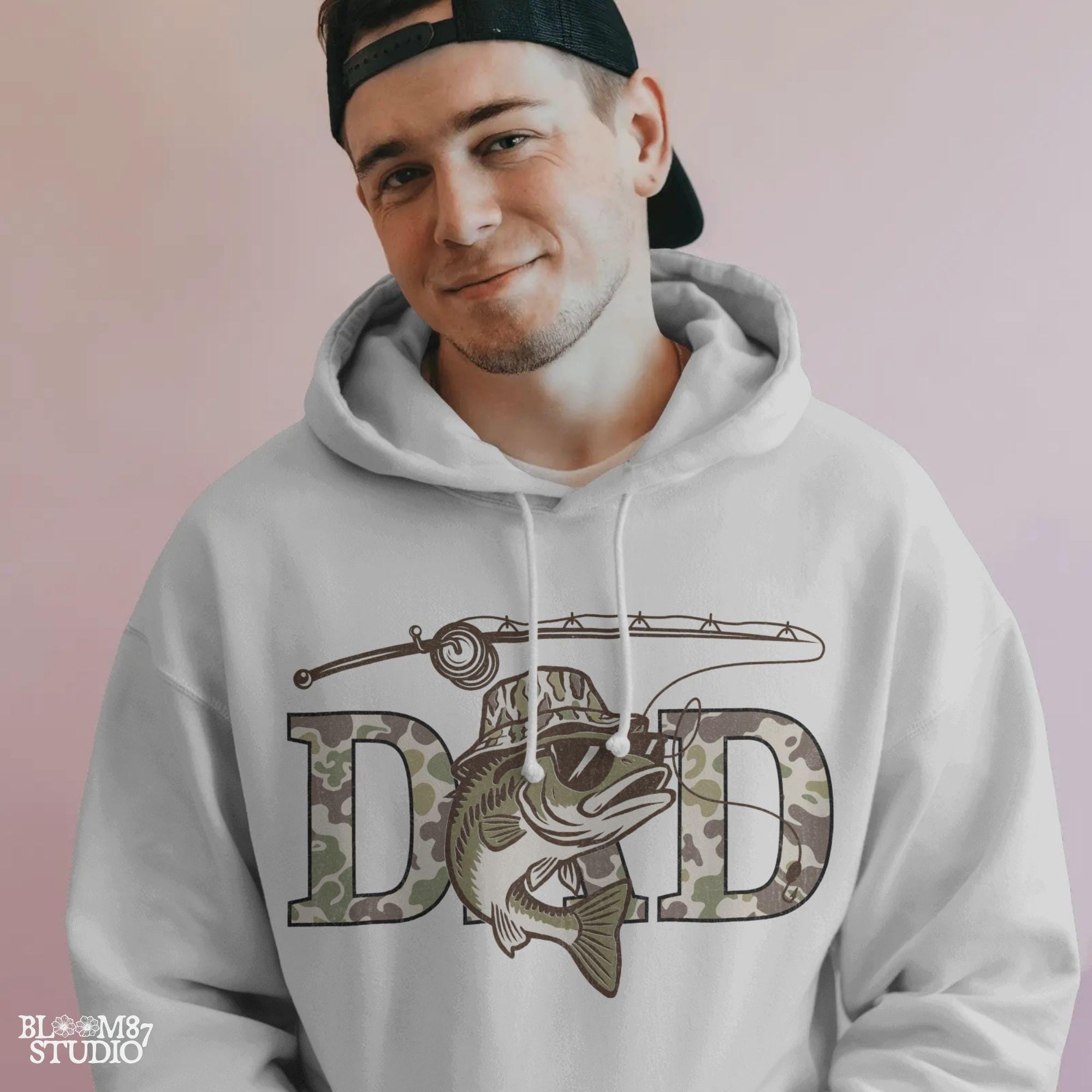 A funny camo bass fish wearing sunglasses and a camo bucket hat, with large camouflage DAD lettering and a fishing pole above.