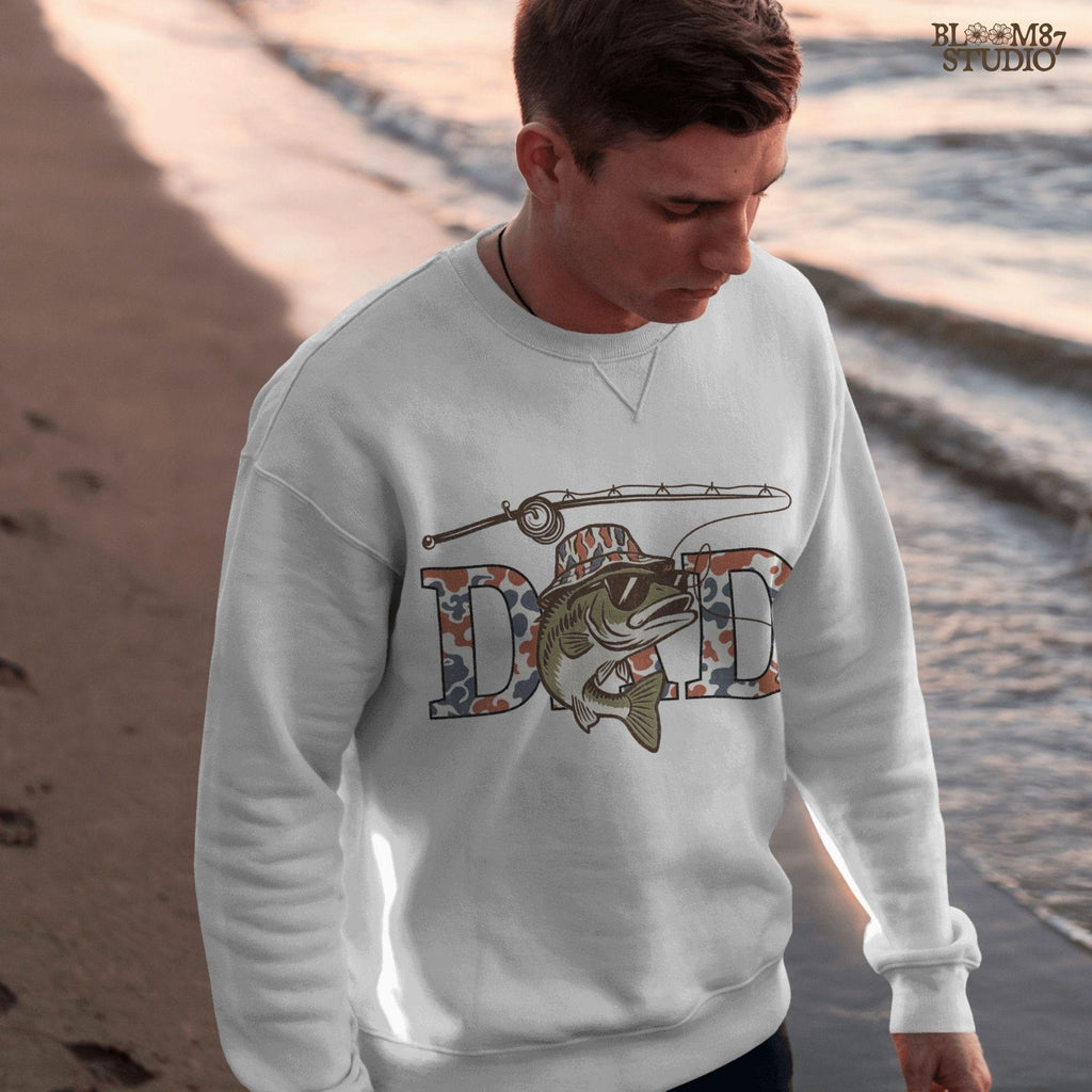 A cool bass fish wearing sunglasses and a bucket hat over red white and blue camo letters spelling DAD, with a fishing rod above.