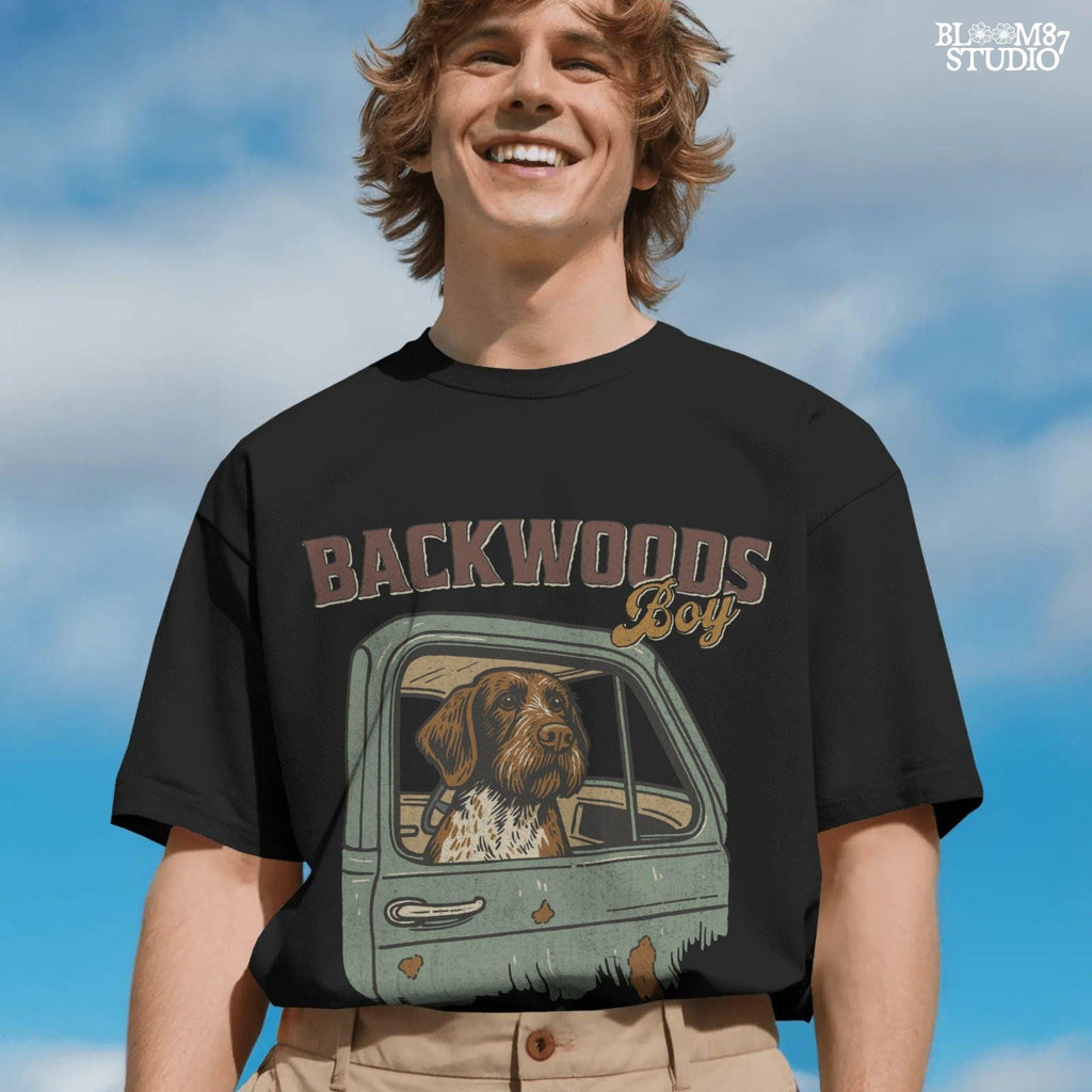 German Wirehaired Pointer hunting dog in rustic truck window with text “Backwoods Boy” and phrase “Loyal Dogs. Dirty Trucks.”