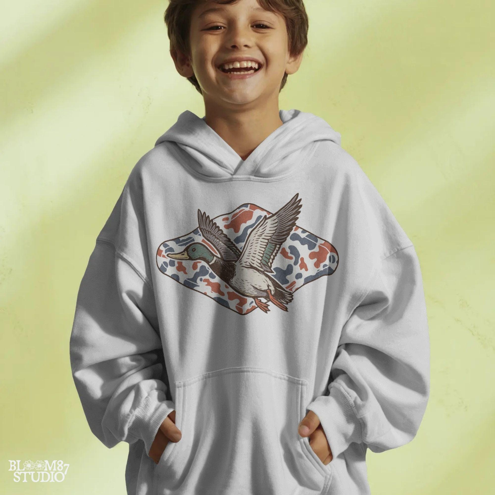 Mallard duck flying over a red, white, and blue camo background, patriotic hunting-themed PNG graphic for 4th of July projects.