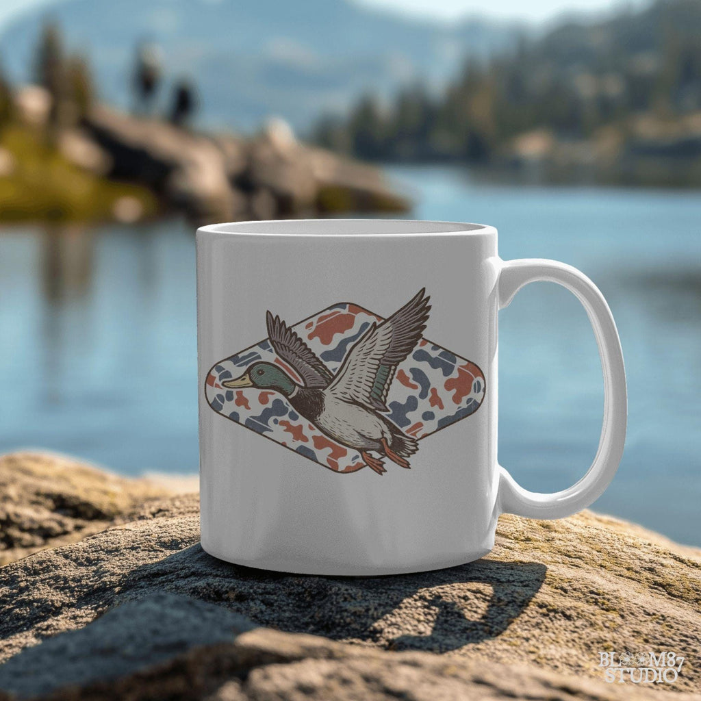 Mallard duck flying over a red, white, and blue camo background, patriotic hunting-themed PNG graphic for 4th of July projects.