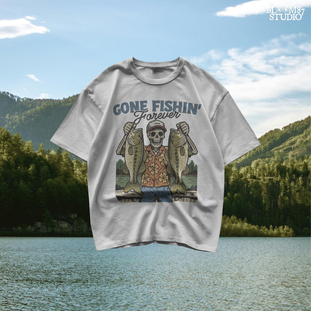 A skeleton wearing a red cap and orange floral shirt stands on a dock holding two large bass fish with the words “Gone Fishin’ Forever” above.