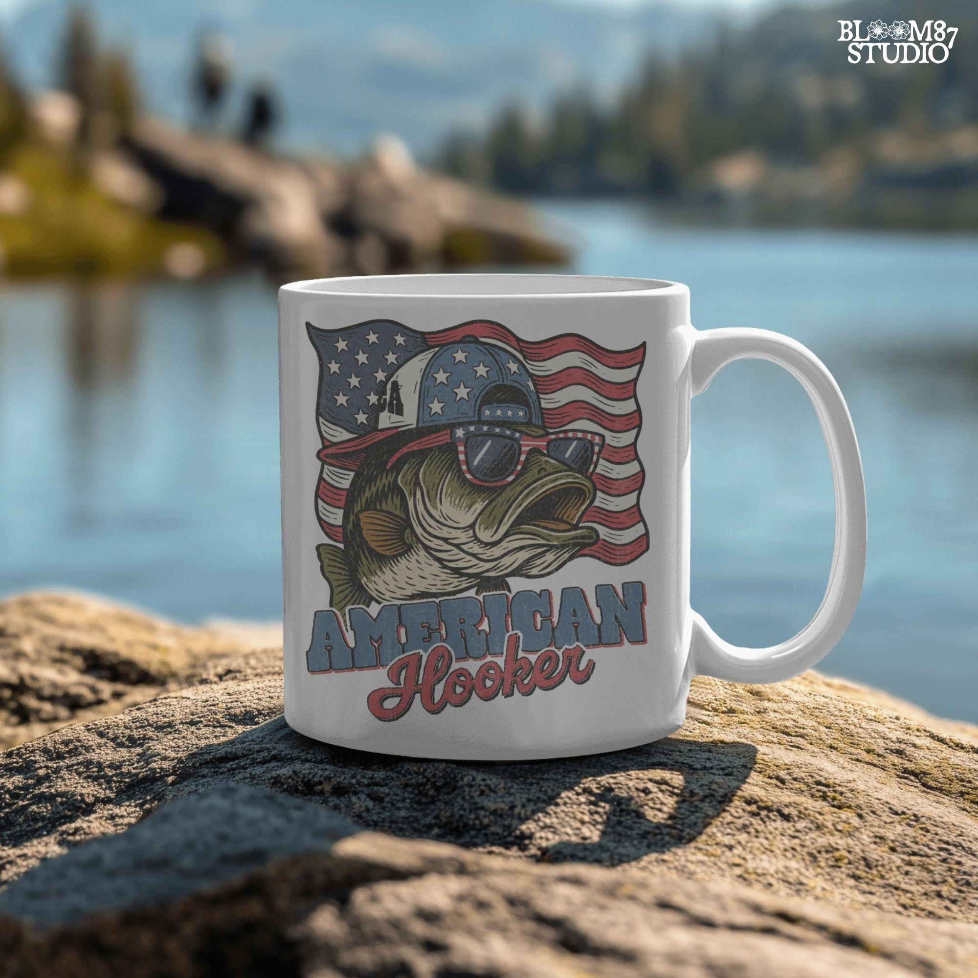 Patriotic cartoon largemouth bass wearing USA sunglasses and a hat in front of the American flag, with the text “American Hooker”.