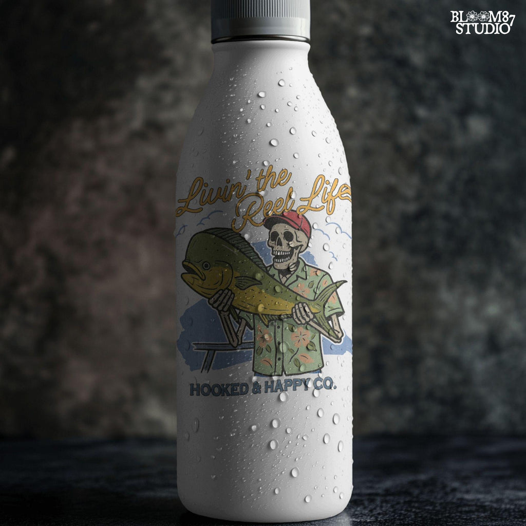 Cartoon skeleton in tropical shirt holding a mahi-mahi fish with text “Livin’ the Reel Life” above and “Hooked & Happy Co.” below.
